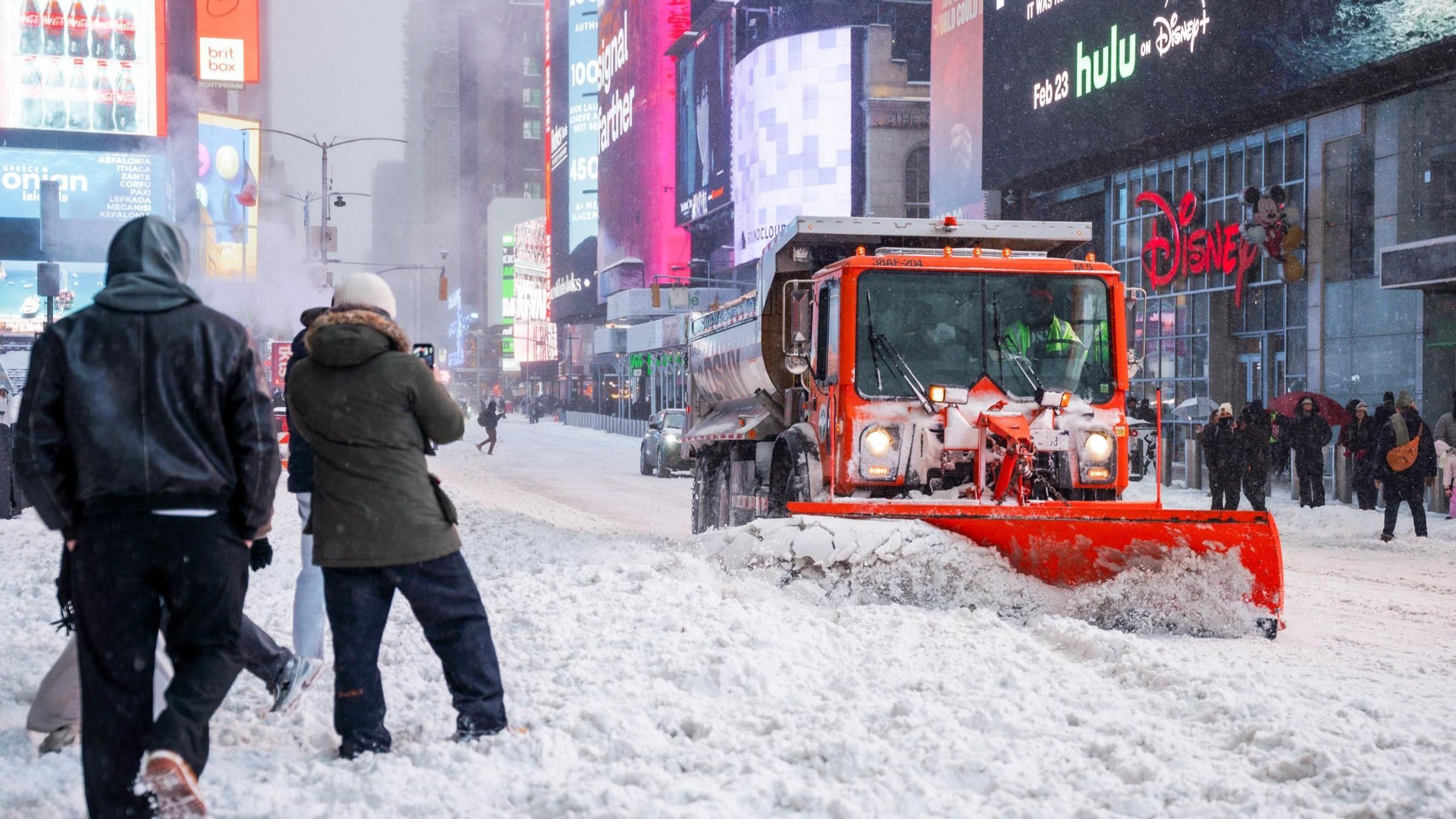 A plow truck clears the snow during a winter storm in Times Square in New York city.