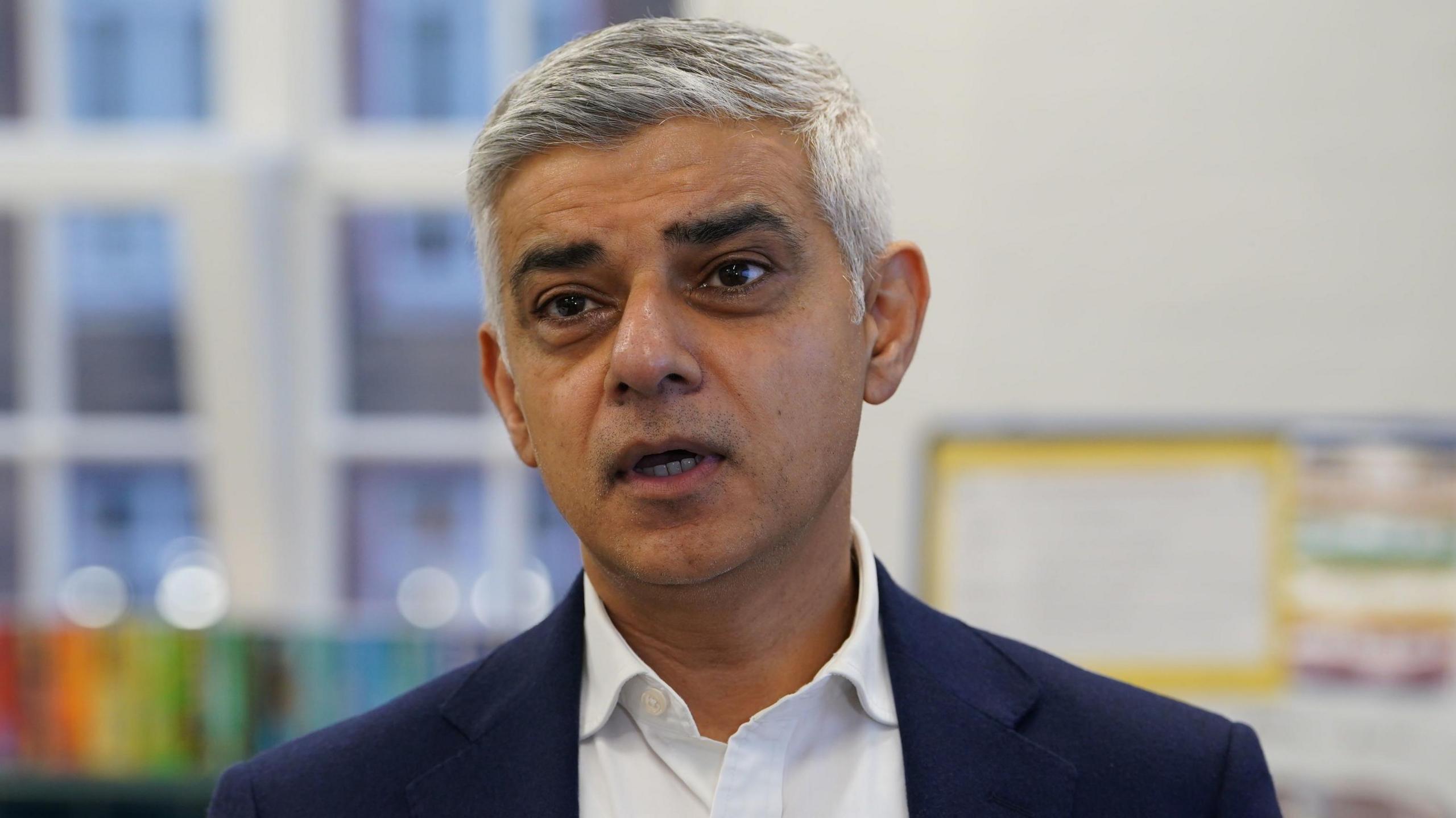 An image of Sir Sadiq Khan who is wearing white shirt and dark blue blazer.