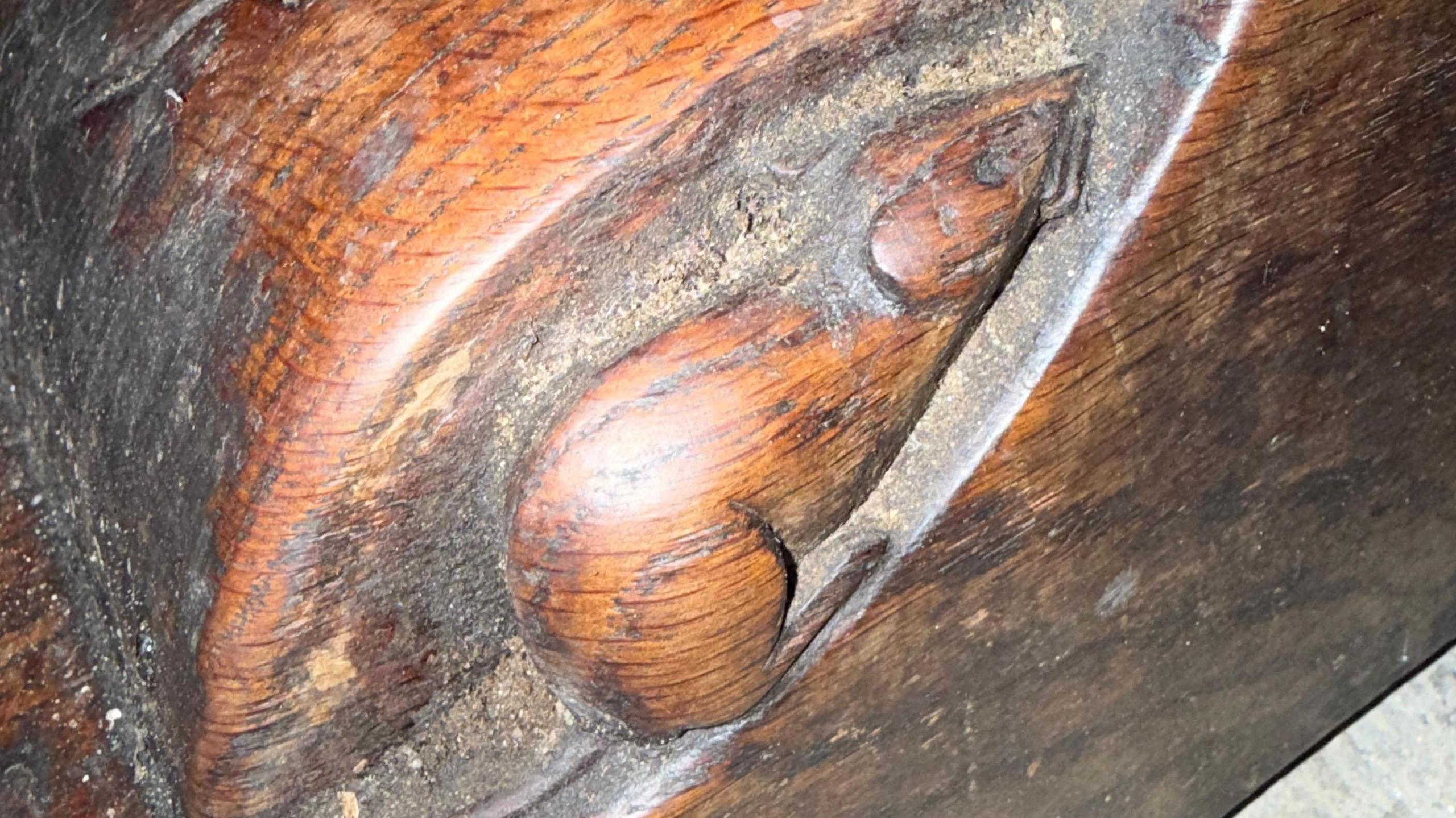 Close-up of a mouse carved on a 1930s Mouseman oak dining table.