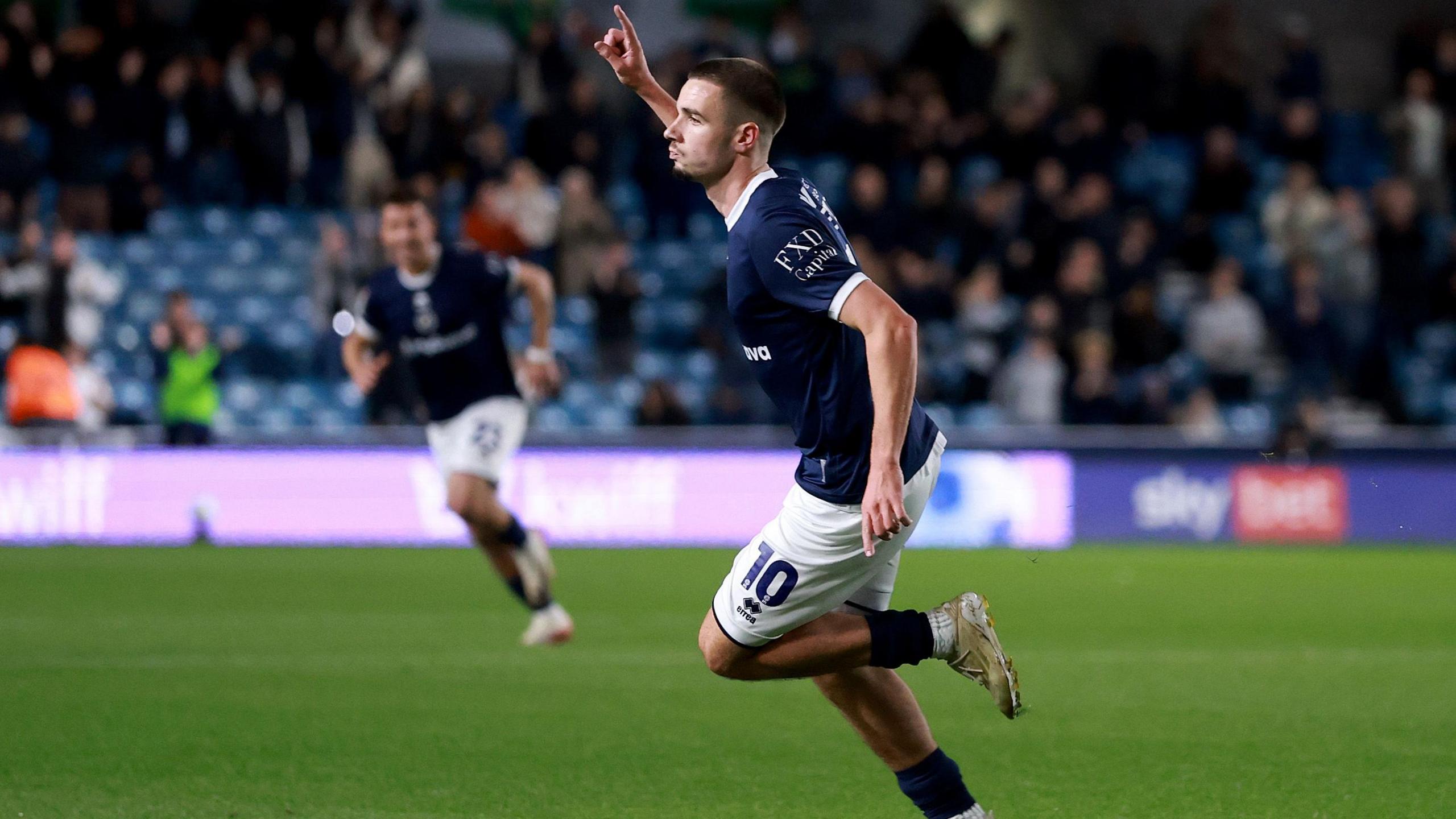 Camiel Neghli celebrates pointing to the sky after scoring for Millwall
