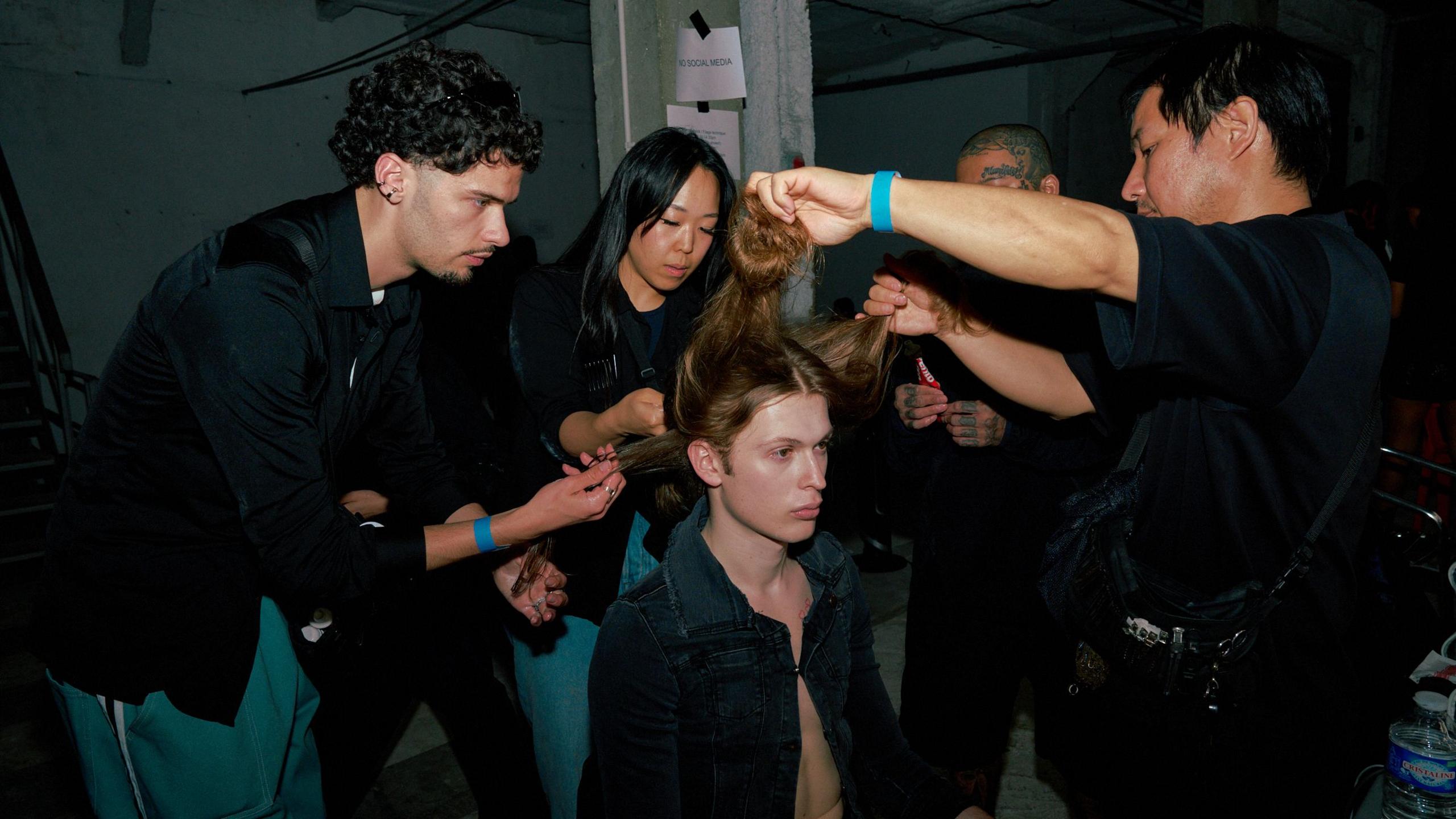 A model's hair is styled backstage at Prototypes