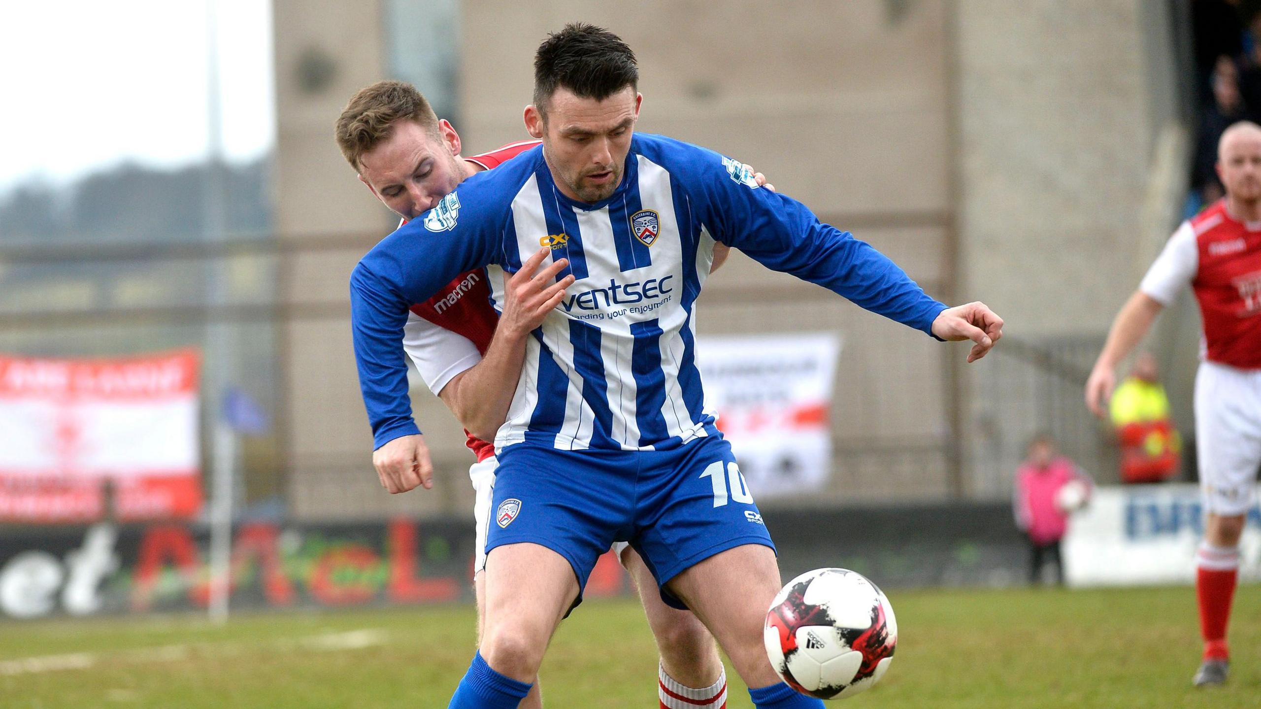 Coleraine's Eoin Bradley holds off Paul Finnegan of Larne