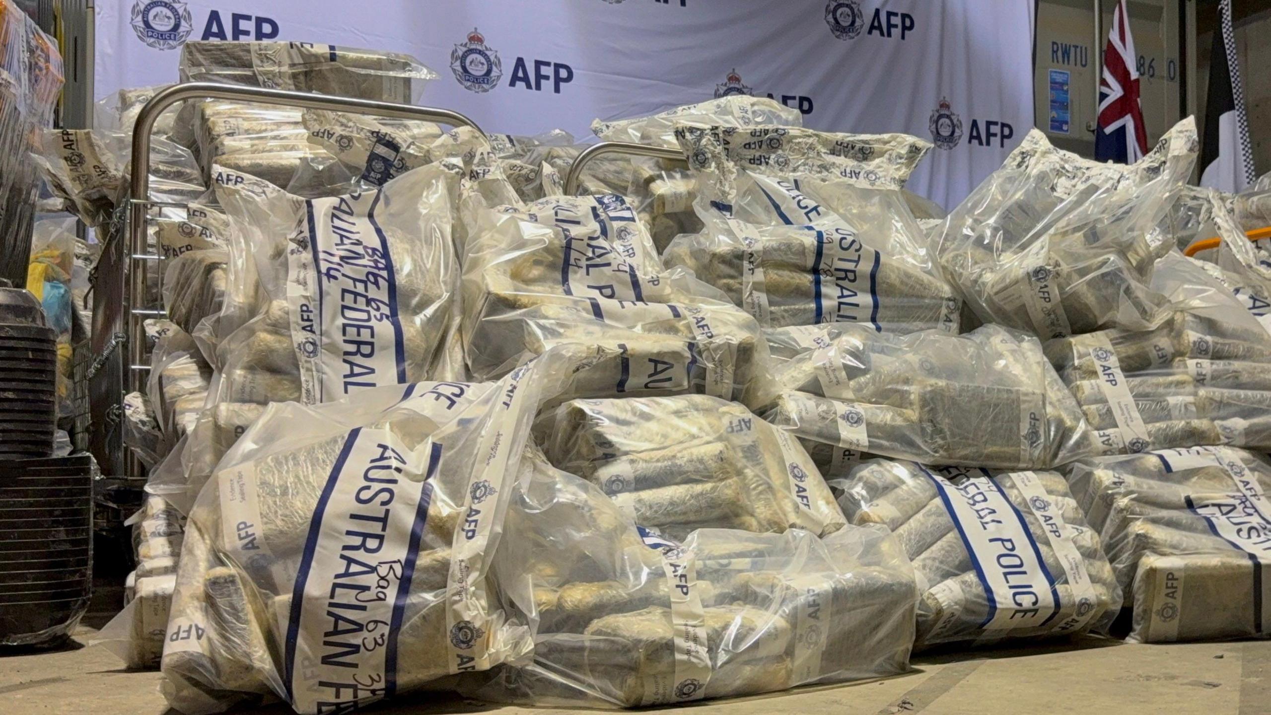 A pile of large plastic bags containing dozens of packages and bearing the label of Australian Federal Police