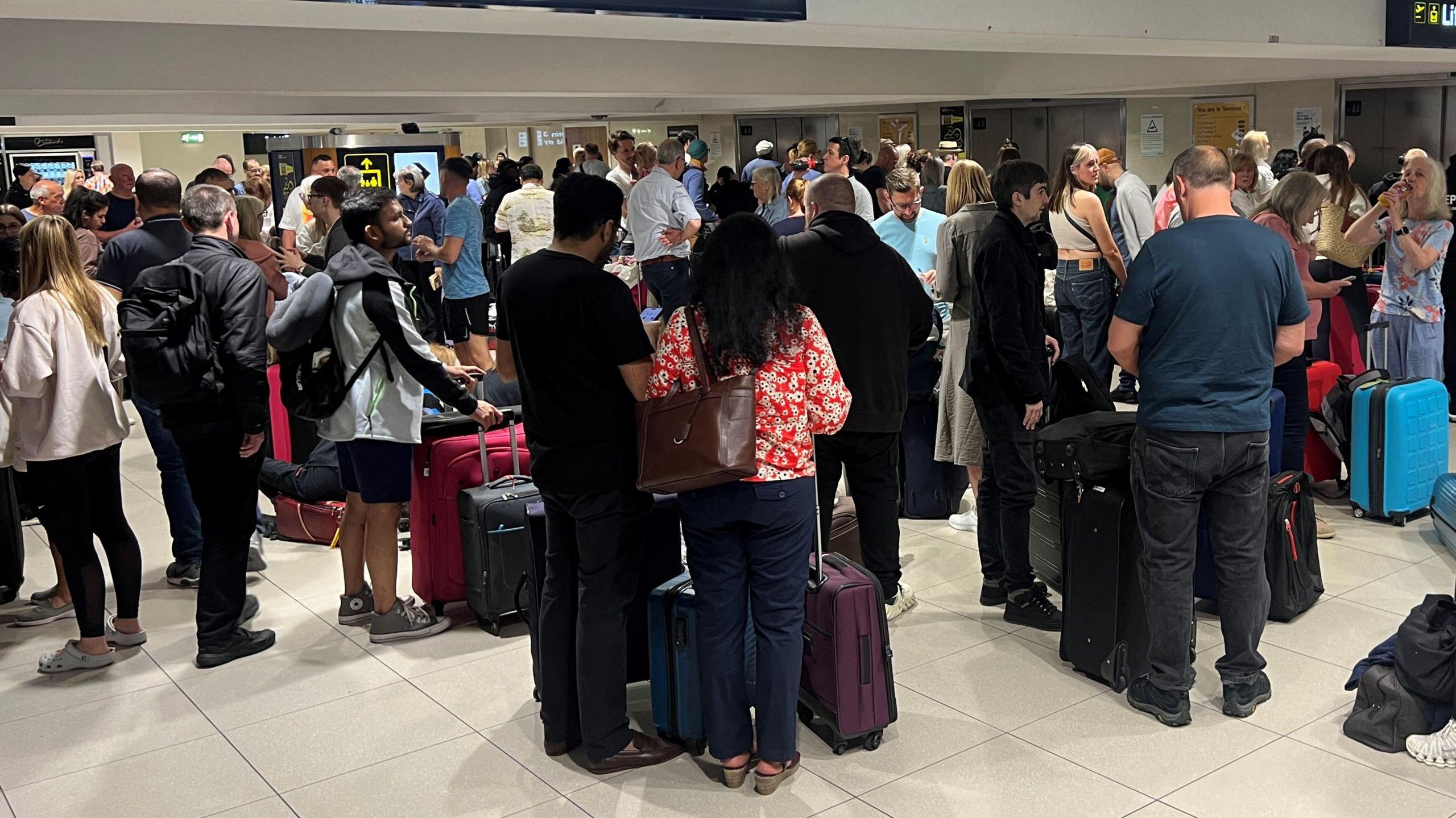 People queuing at Manchester Airport after their flights were cancelled