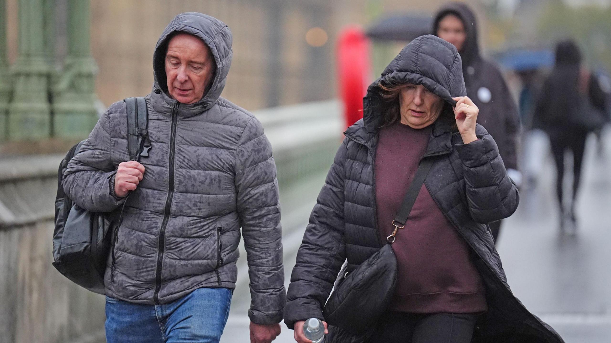 Lady holding coat hood on Westminster Bridge, London
