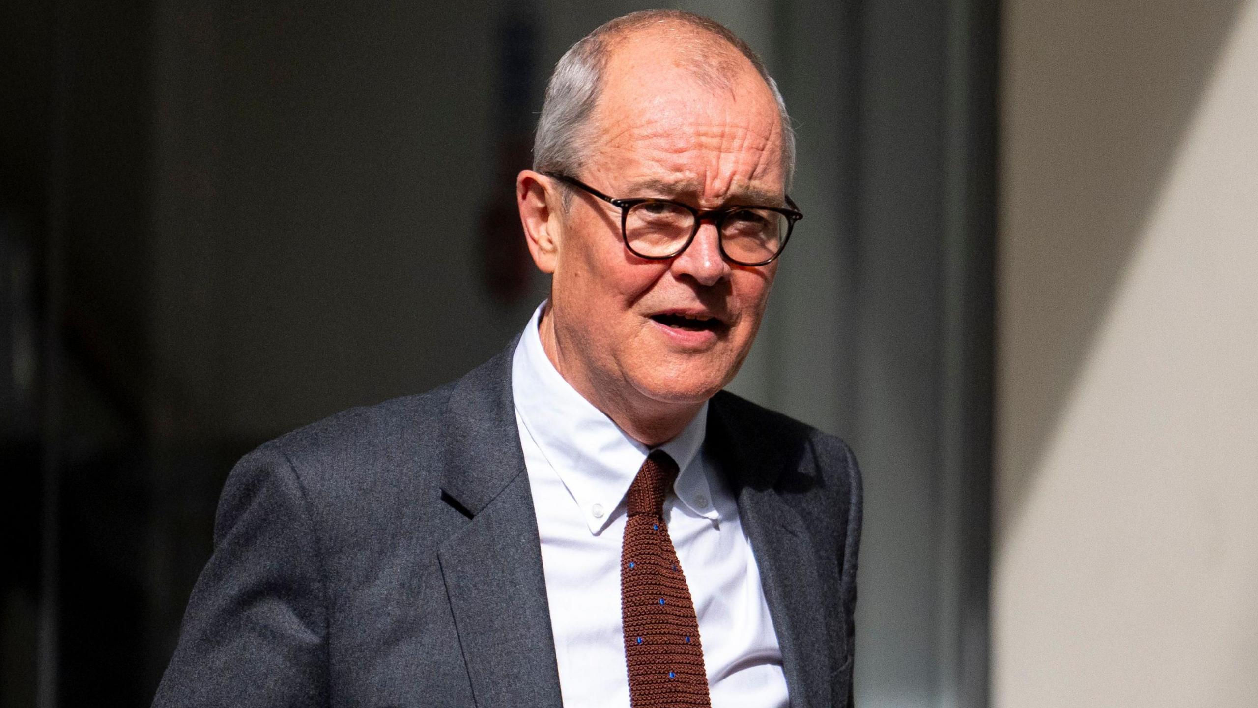 Patrick Vallance, wearing a grey suit and holding a folder, leaves the Covid inquiry after giving evidence