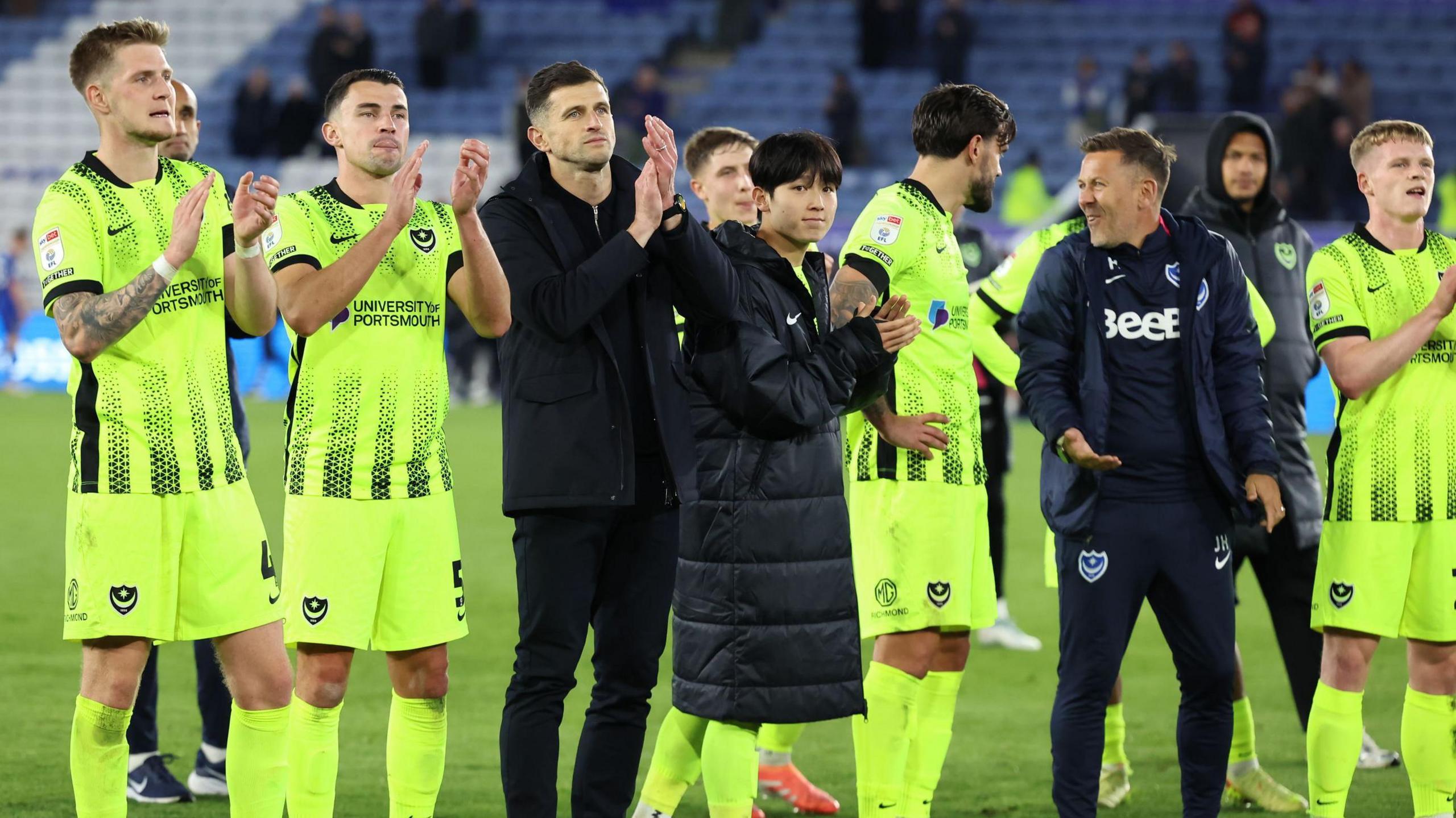 Portsmouth players and staff clap the travelling support at the King Power Stadium