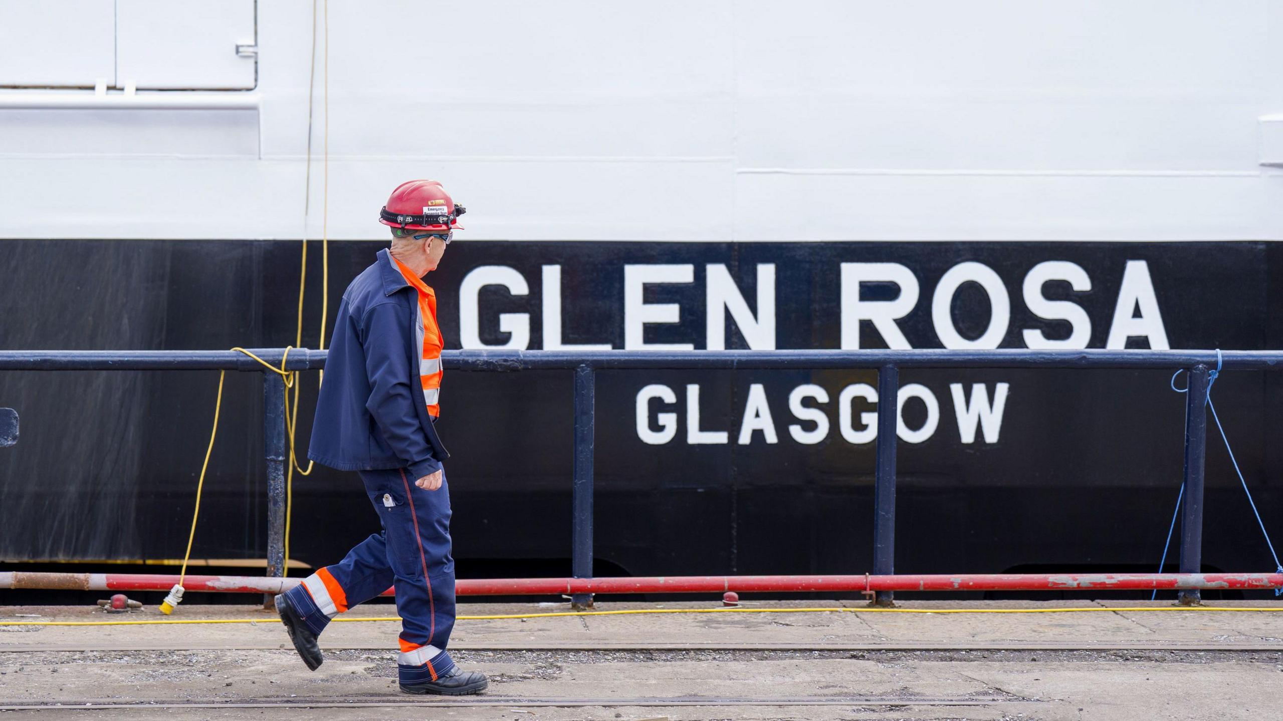 Neach-obrach aig Gàrradh MhicFheargais a' coiseachd seachad air an Glen Rosa