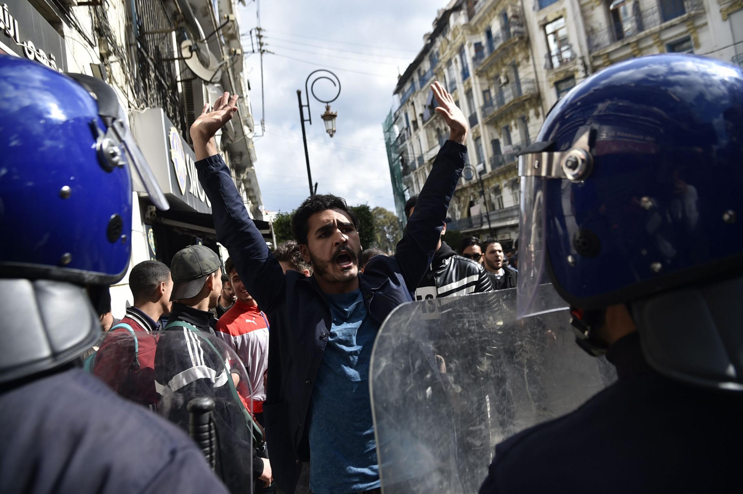 Members of the security forces stand guard as Algerian students protest on the main campus of the University of Algiers against the fifth term of Abdelaziz Bouteflika