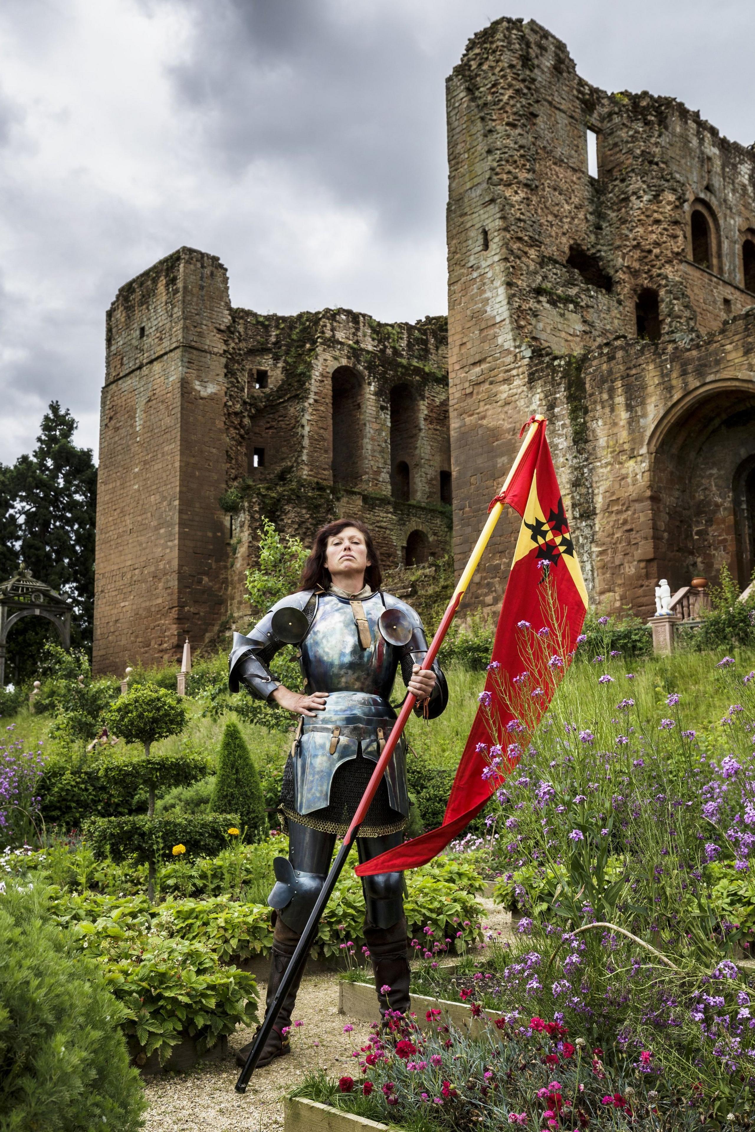 Nicky Willis in a garden holding a flag