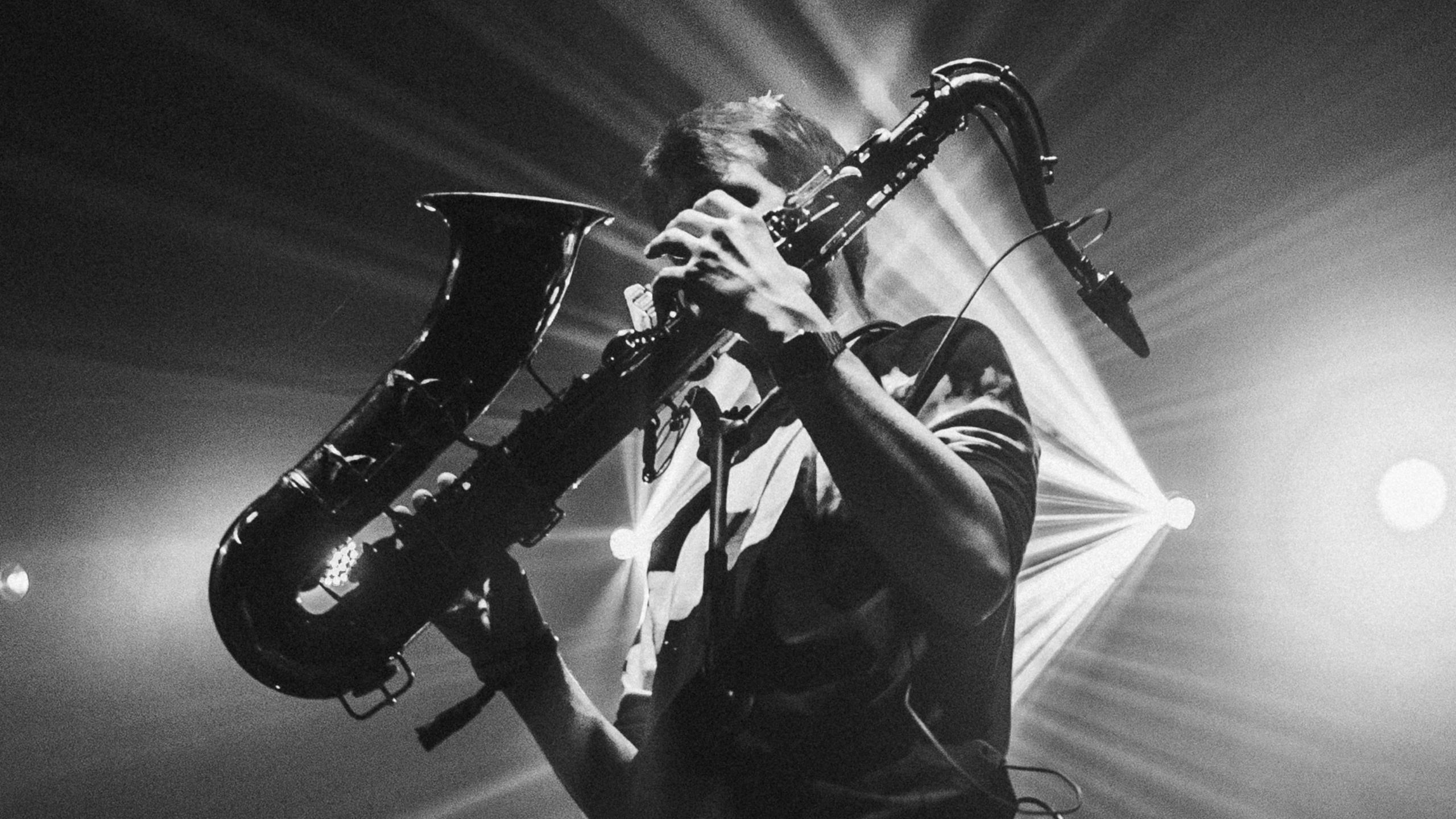 Black and white photo of Andrew Hayes playing a saxophone