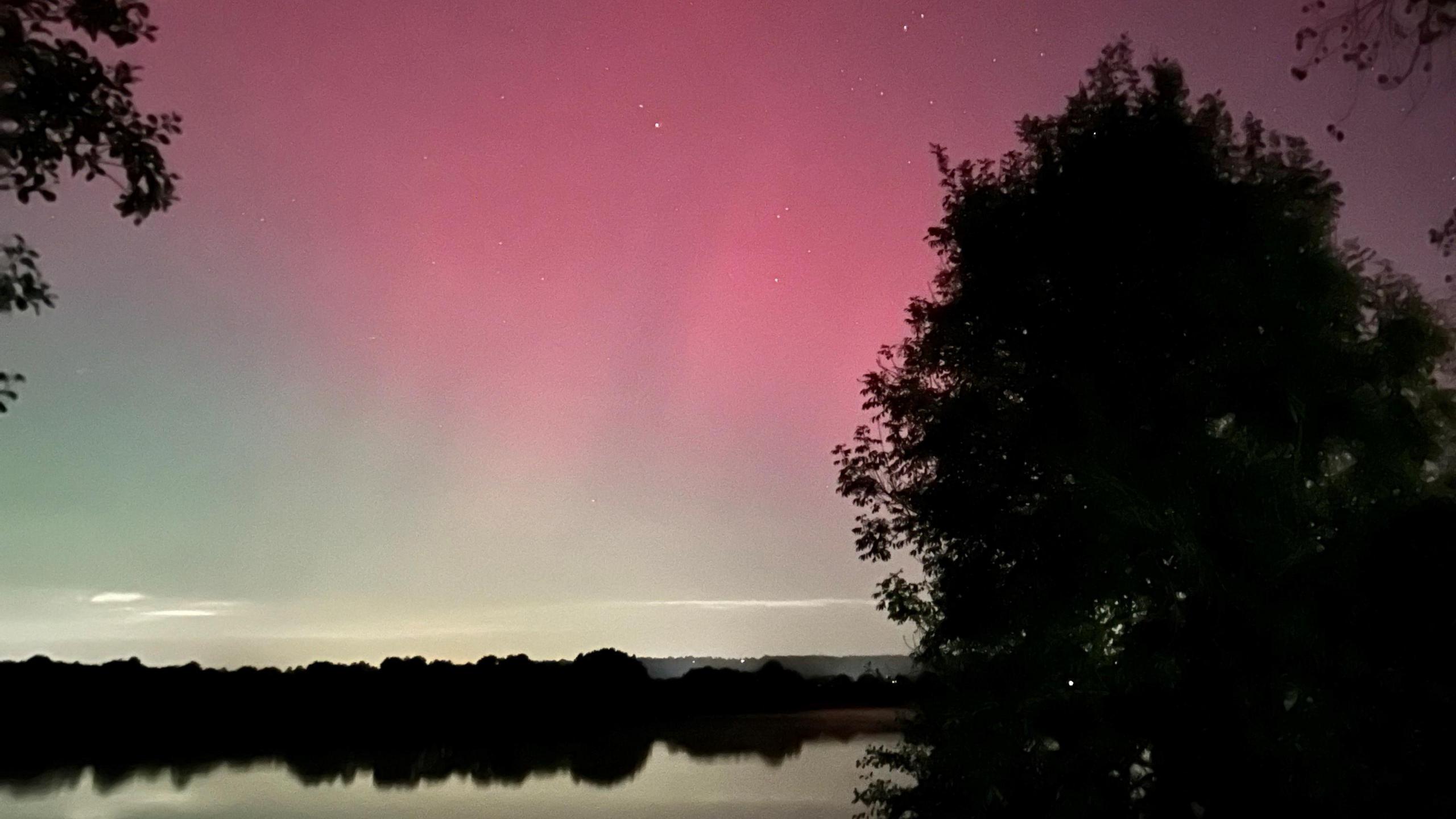 The Northern Lights reflect off water