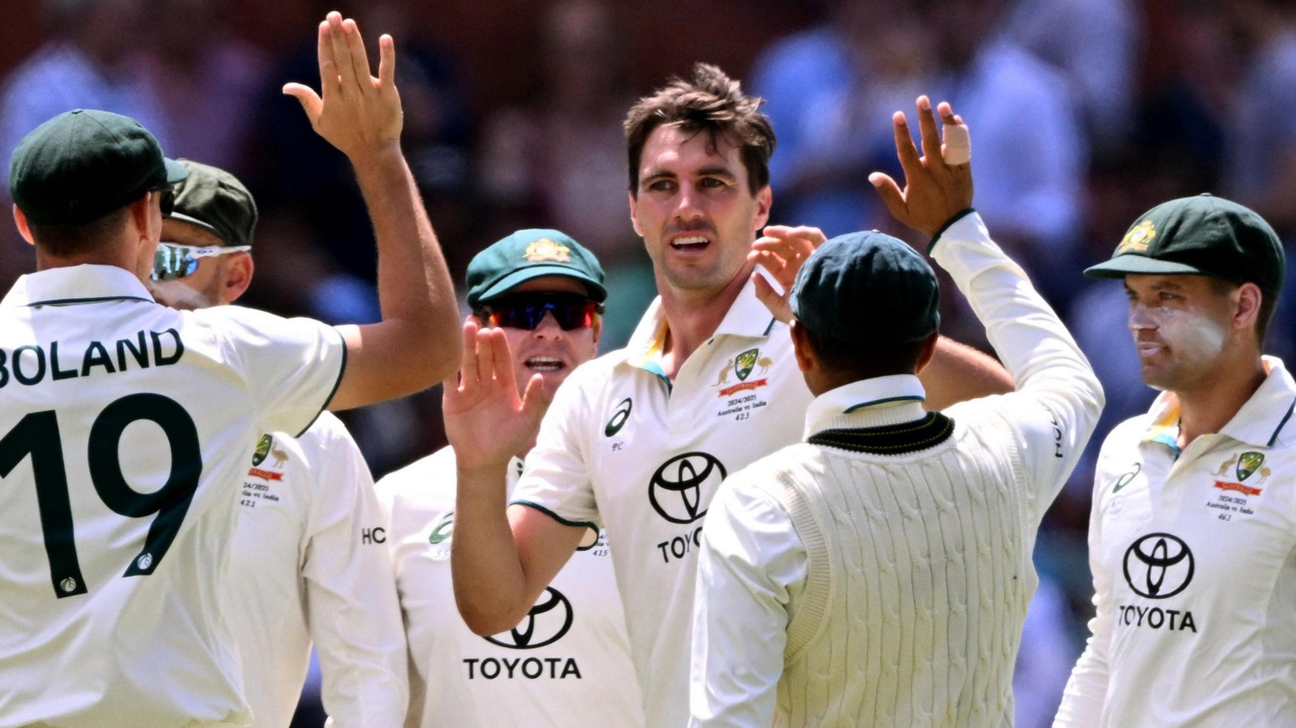 Australia captain Pat Cummins celebrates taking five wickets with his team-mates