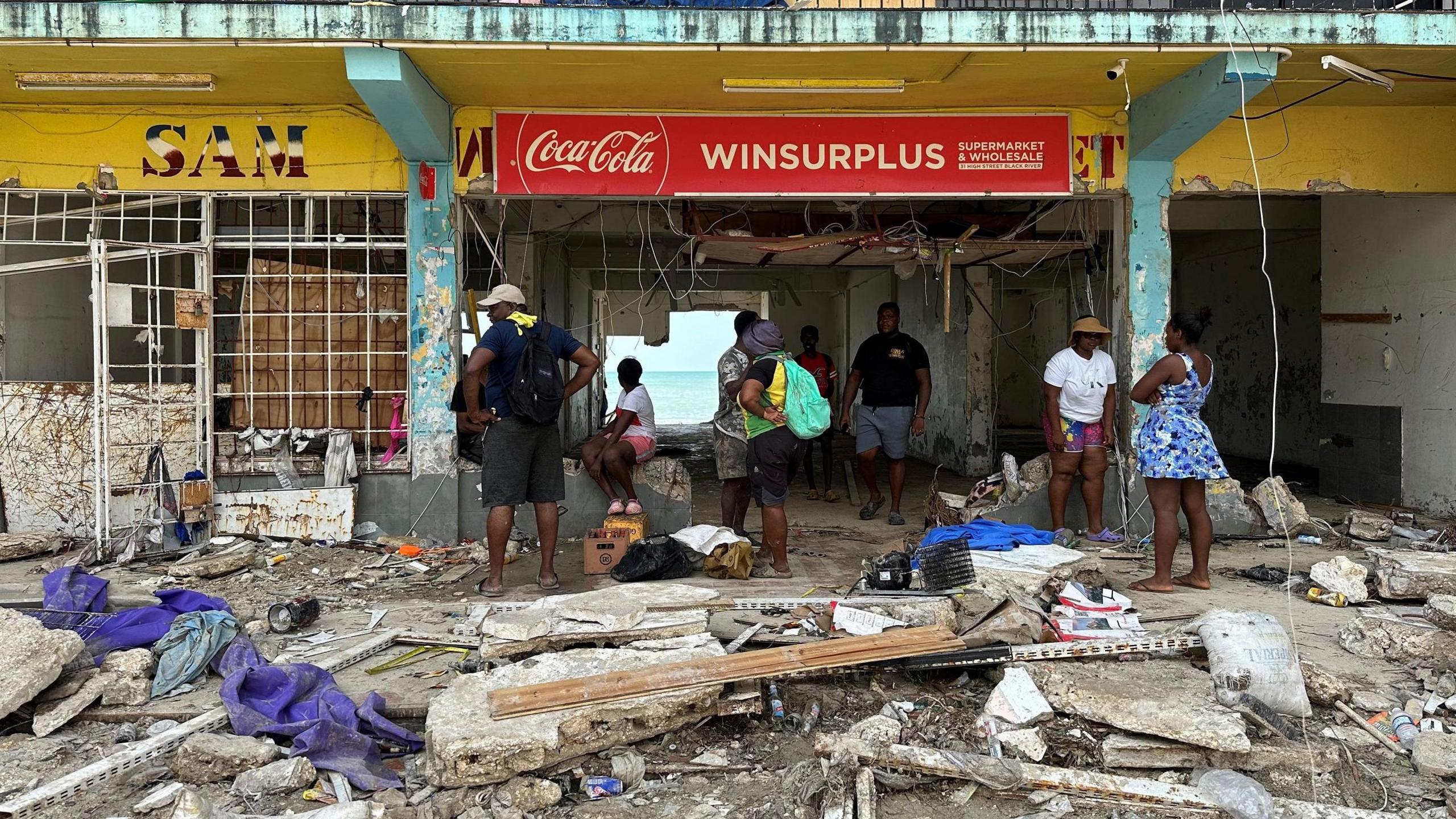 People are searching through debris and damaged stores for supplies