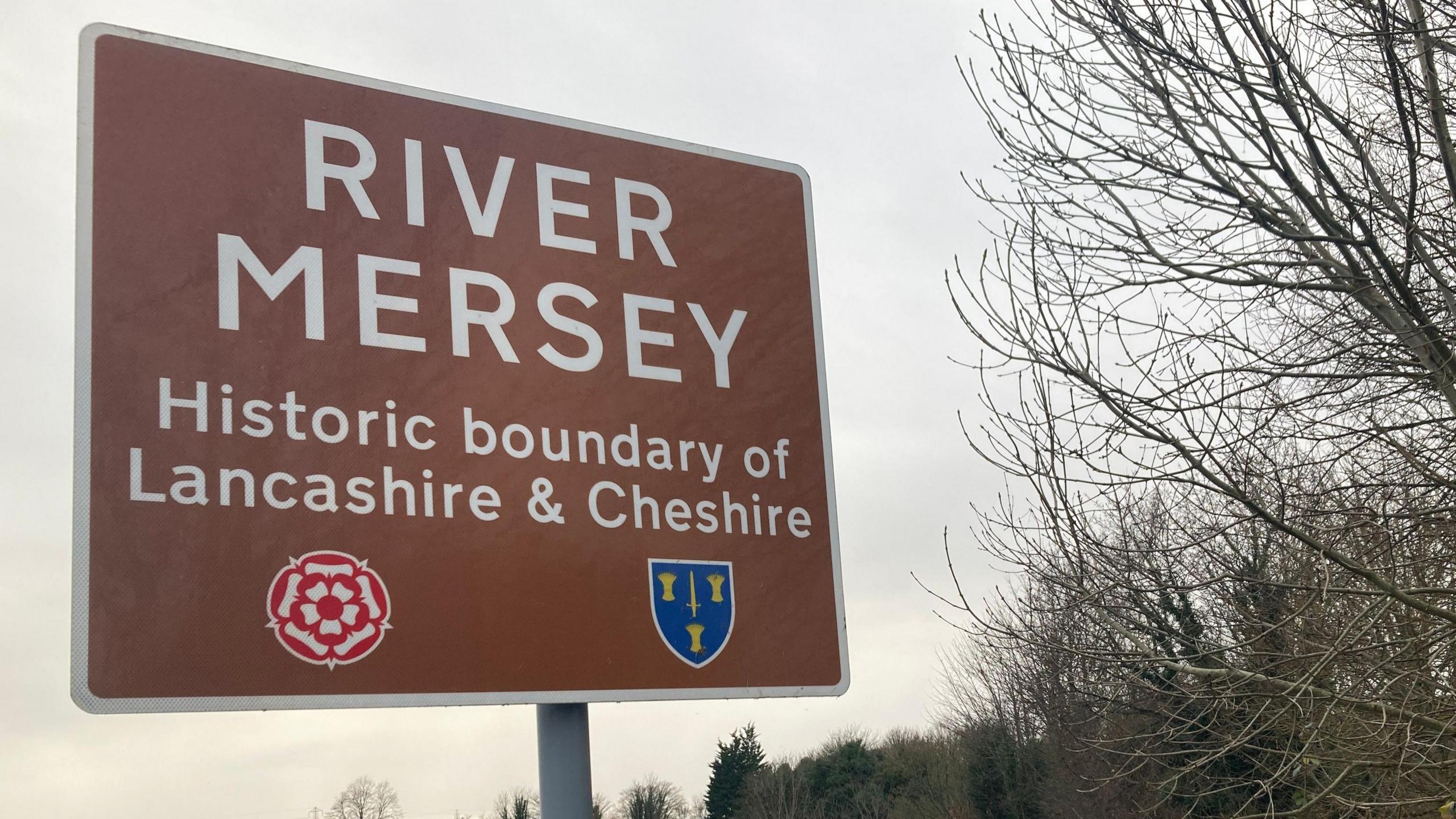 A sign next to the River Mersey in Greater Manchester which reads "River Mersey, historic boundary of Lancashire and Cheshire"