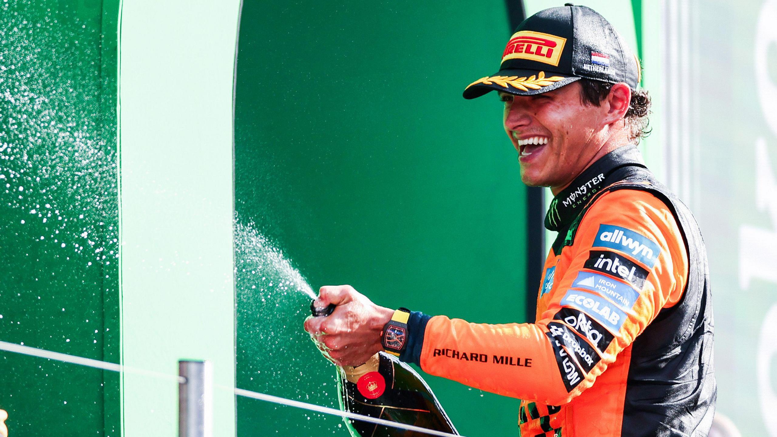 Lando Norris sprays champagne on the podium after his win at the 2026 Dutch Grand Prix