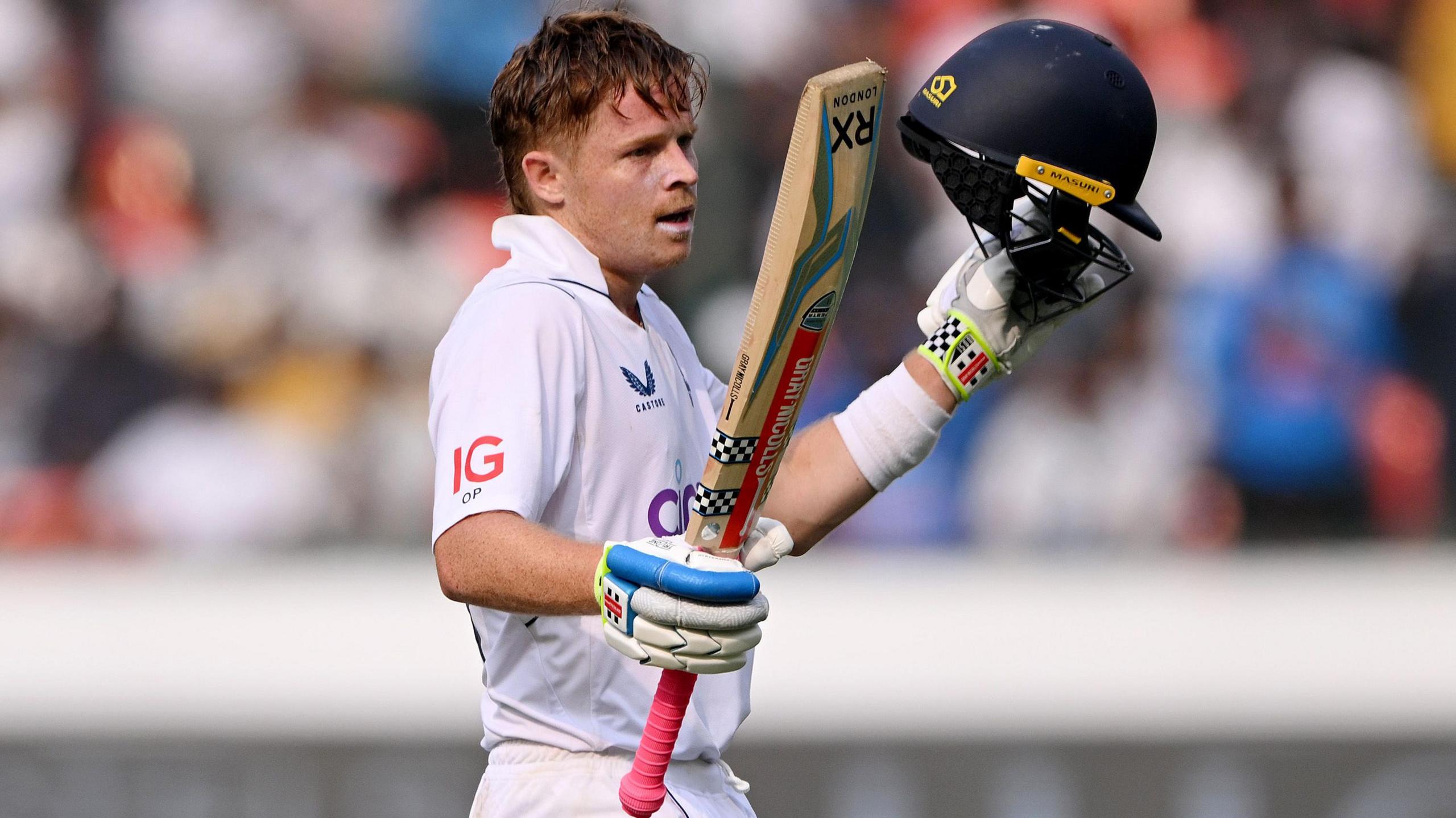 Ollie Pope raises his bat after reaching his century in Hyderabad in 2024