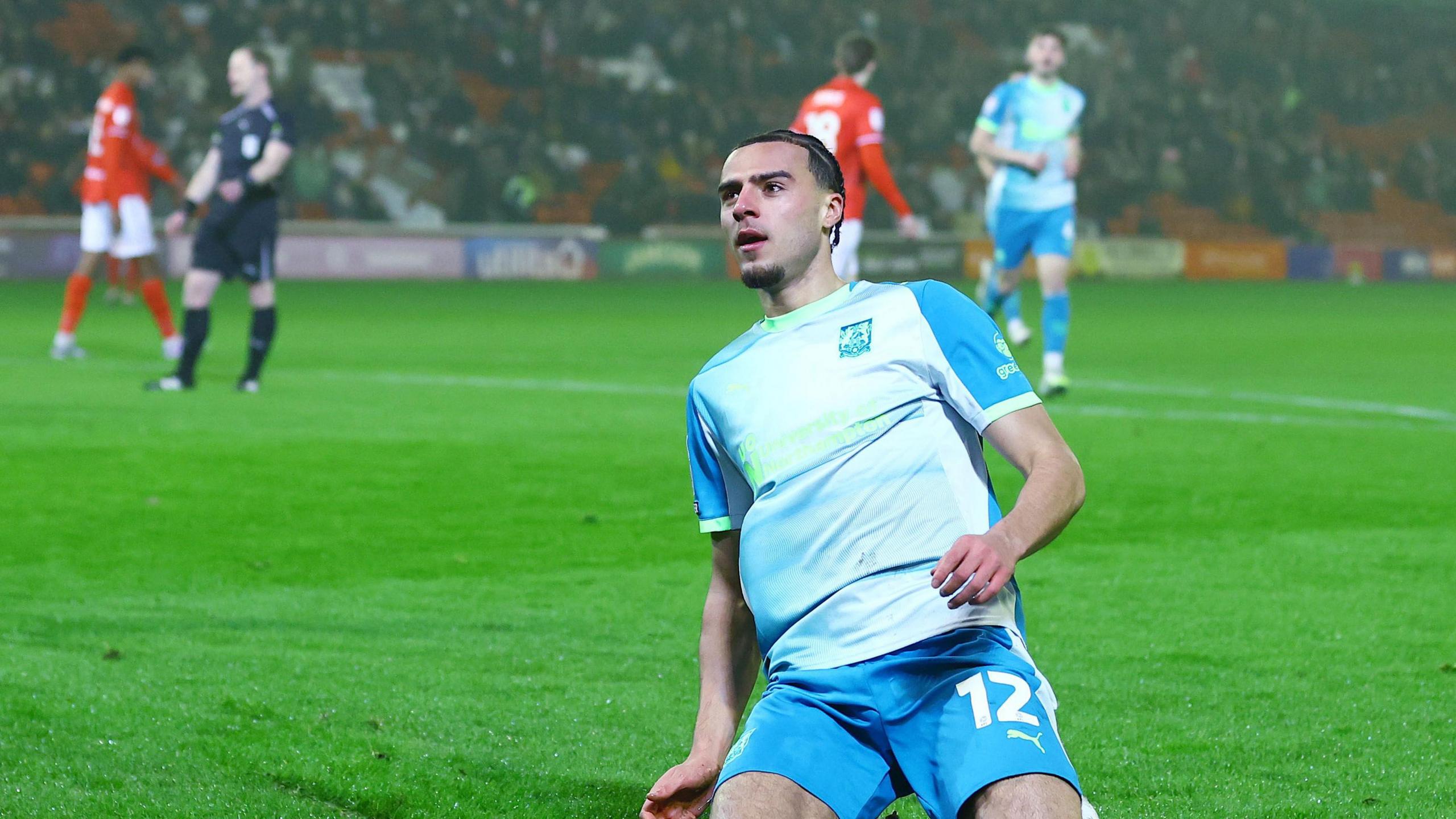 Nesta Guinness-Walker slides across the pitch on his knees after scoring for Northampton Town at Barnsley