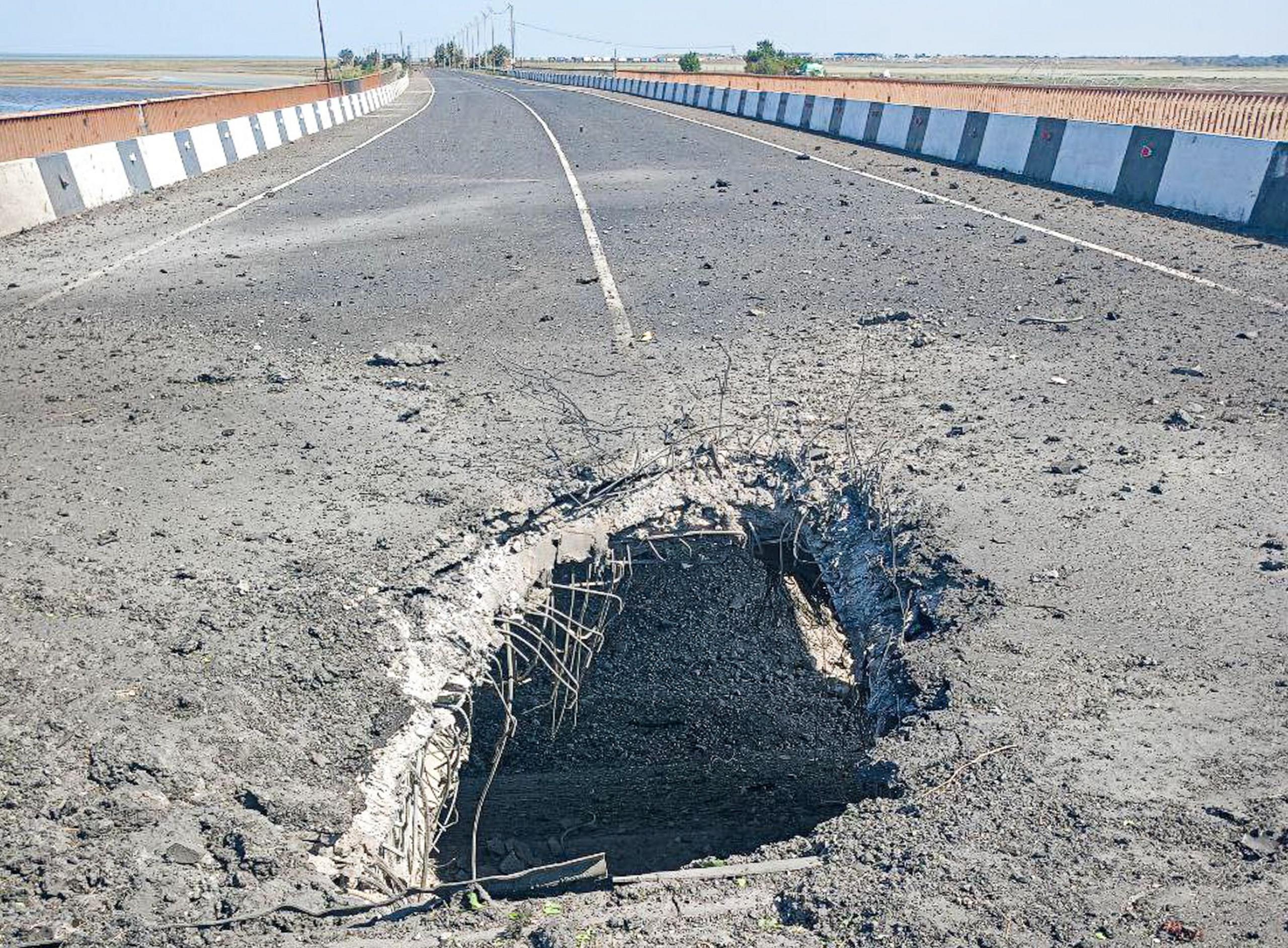 Blast damage to a bridge: A gaping hole can be seen in the middle of the road surface.