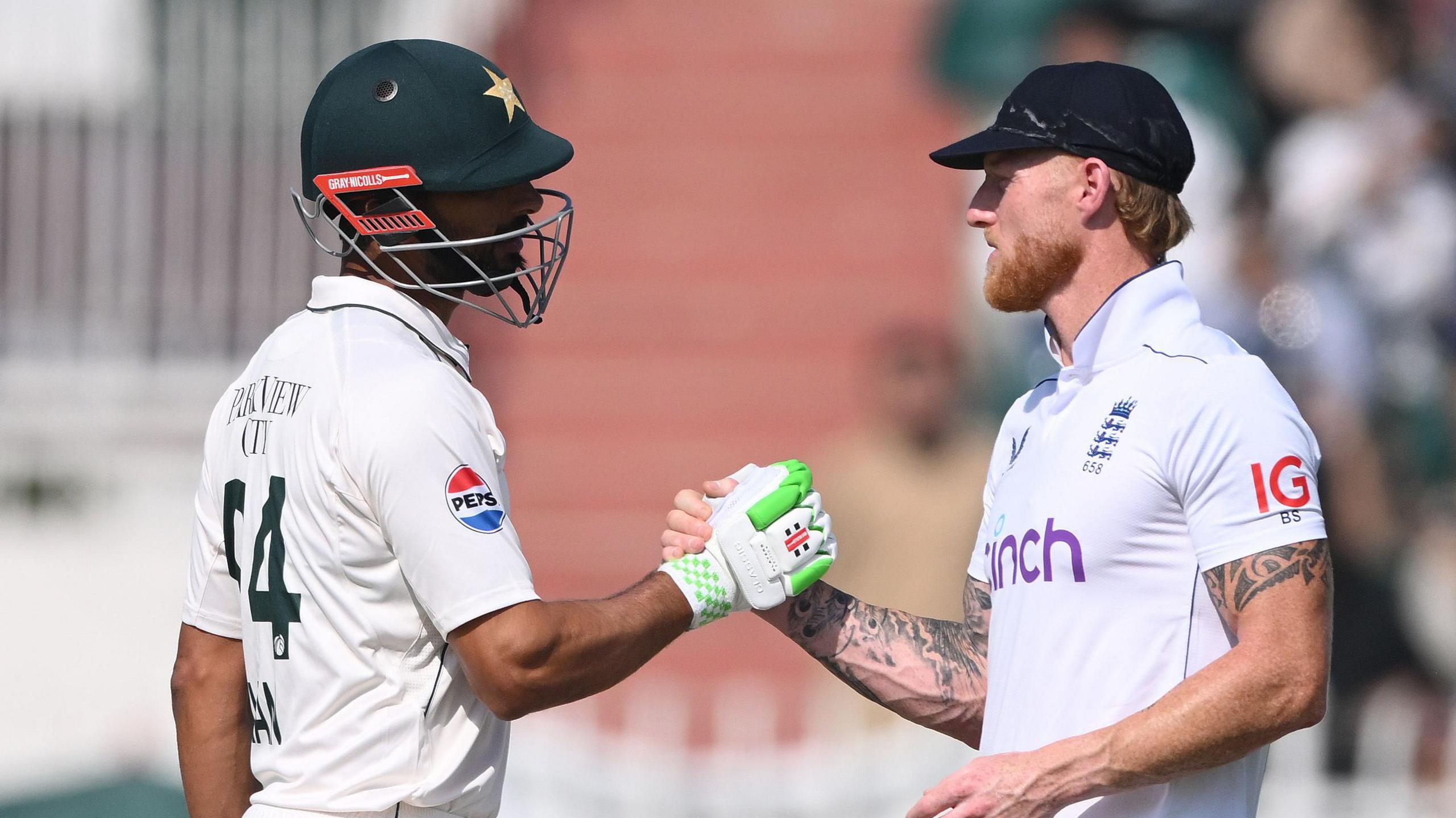 Pakistan batter Shan Masood and England captain Ben Stokes shake hands in 2024