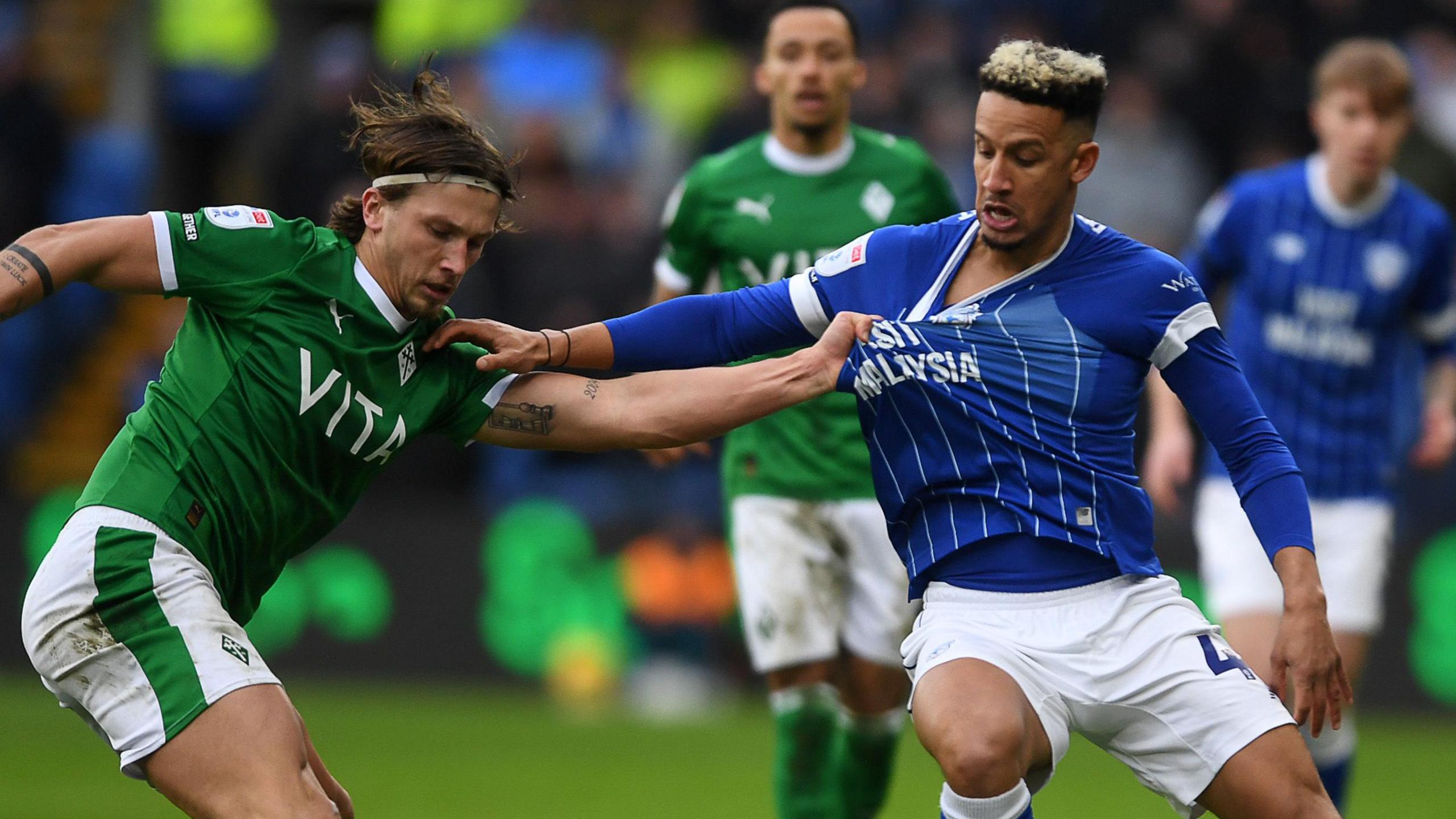 Callum Robinson (right) of Cardiff City has his shirt pulled by Brad Hills of Stockport County