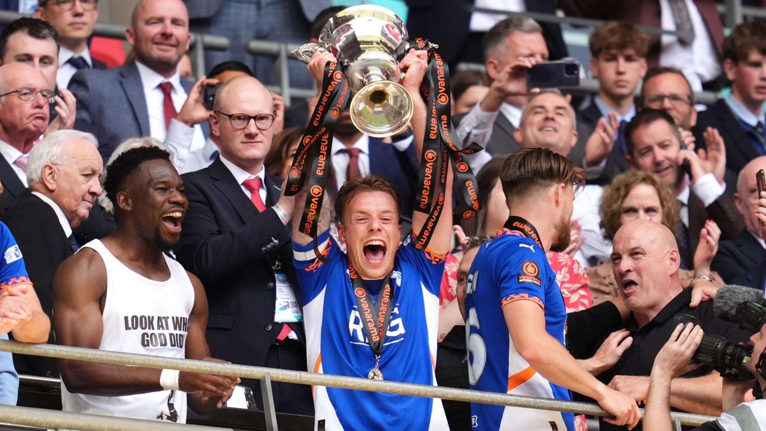 Oldham Athletic's Tom Conlon lifts the trophy following the Vanarama National League play-off final at Wembley Stadium, London