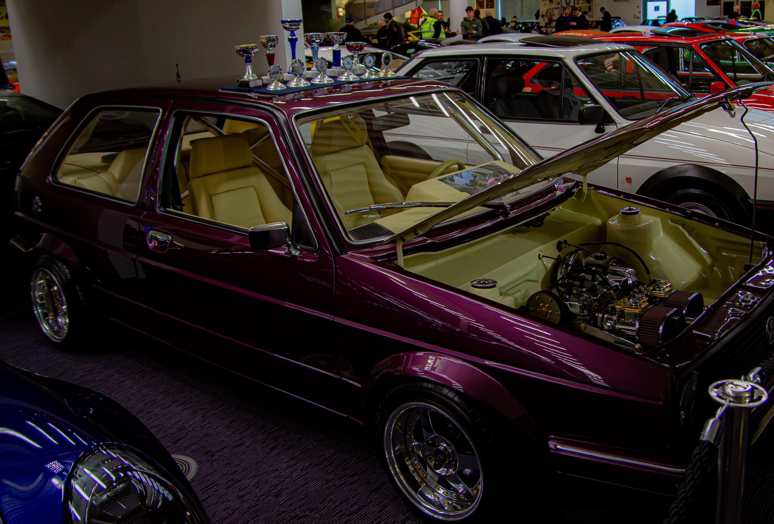 A close up of a shiny purple car. It has its bonnet open.