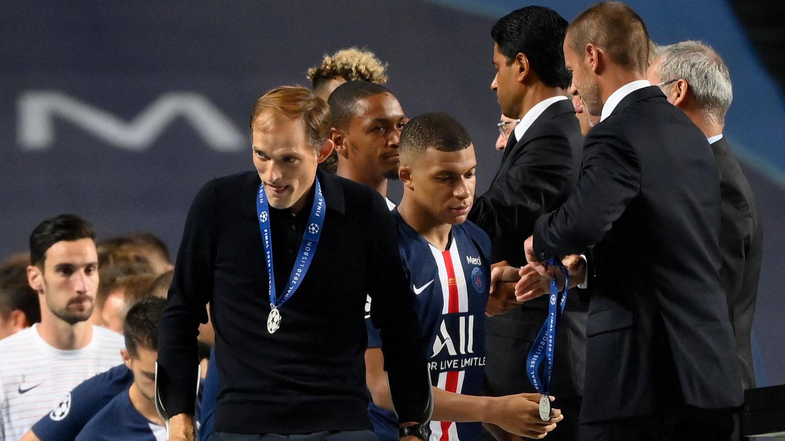 Paris Saint-Germain coach Thomas Tuchel (L) and forward Kylian Mbappe (C) receive their runner-up medals from Uefa president Aleksander Ceferin (R) after Bayern Munich won the Uefa Champions League final 1-0 at the Luz stadium in Lisbon on August 23, 2020. 