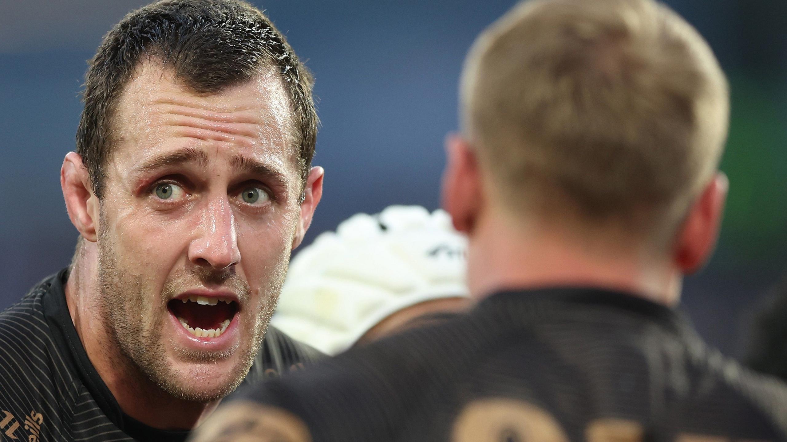 Isaah Yeo, framed in a head and shoulders shot with an out-of-focus team-mate in the foreground, looks off to the left