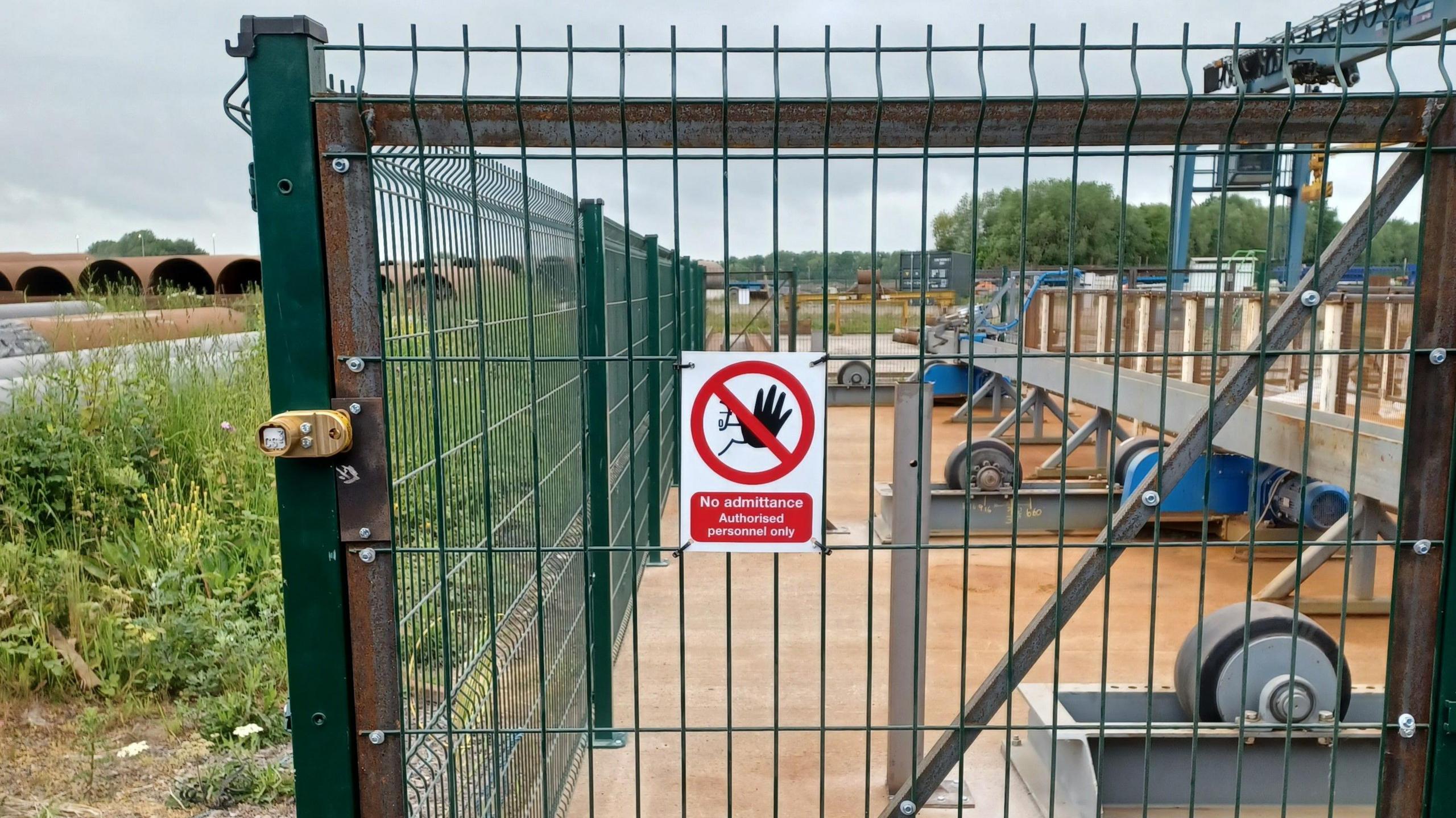 Fence around machinery at a steel site.