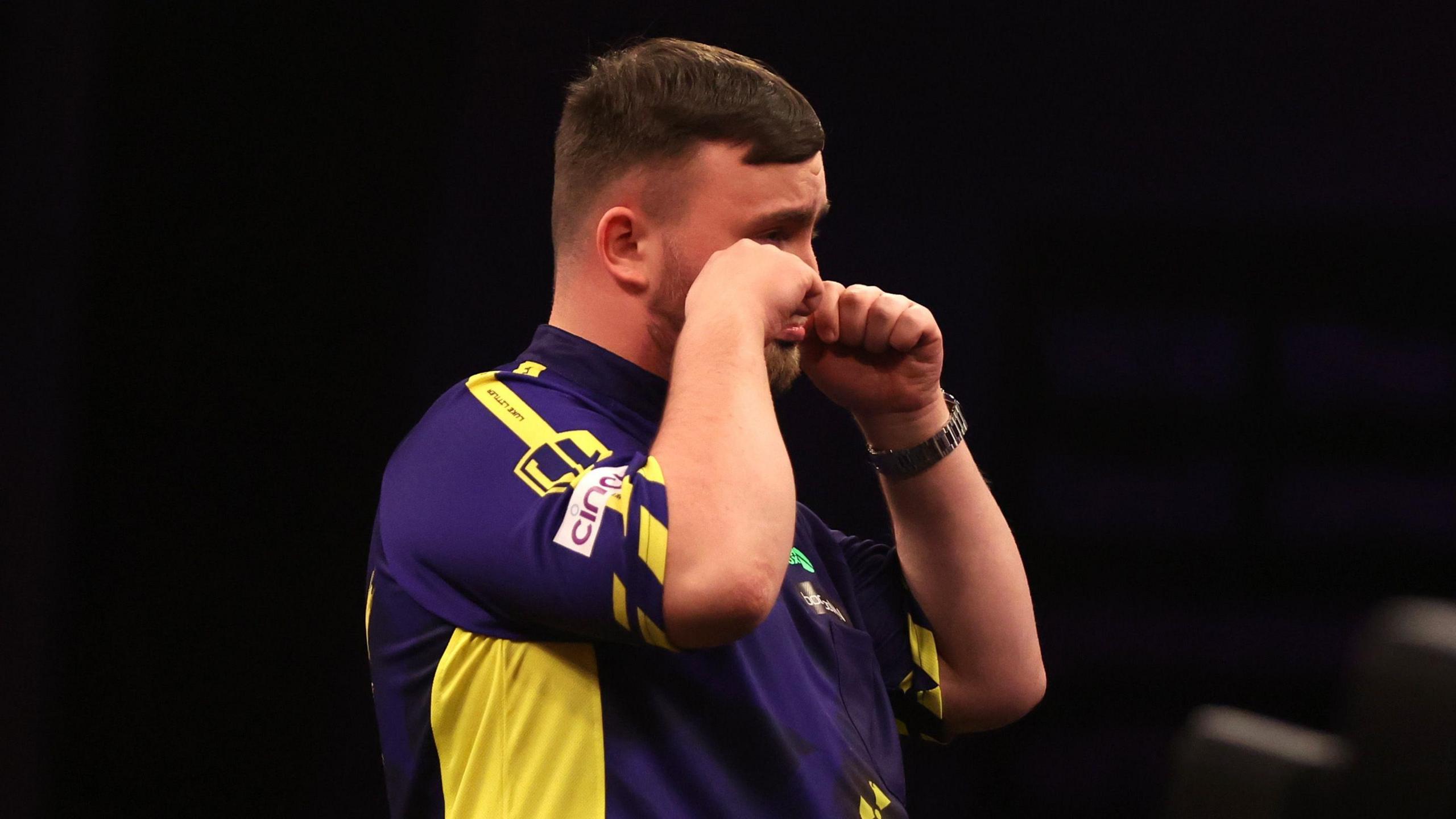 Luke Littler gestures to the Leeds crowd that they are crying during the 2025 Premier League Darts