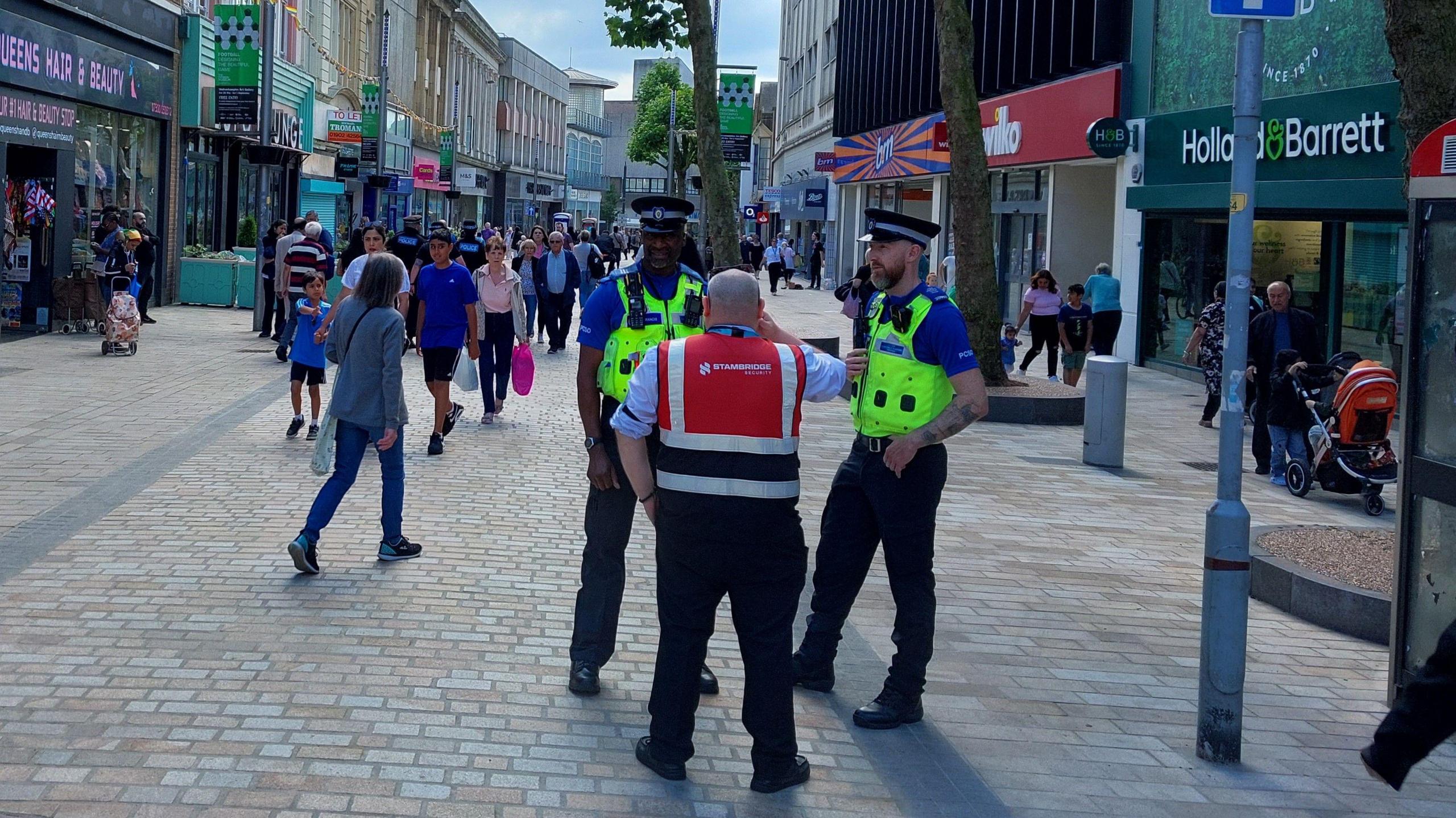 Two uniformed officers talking to people in Dudley Street, which is packed with shoppers