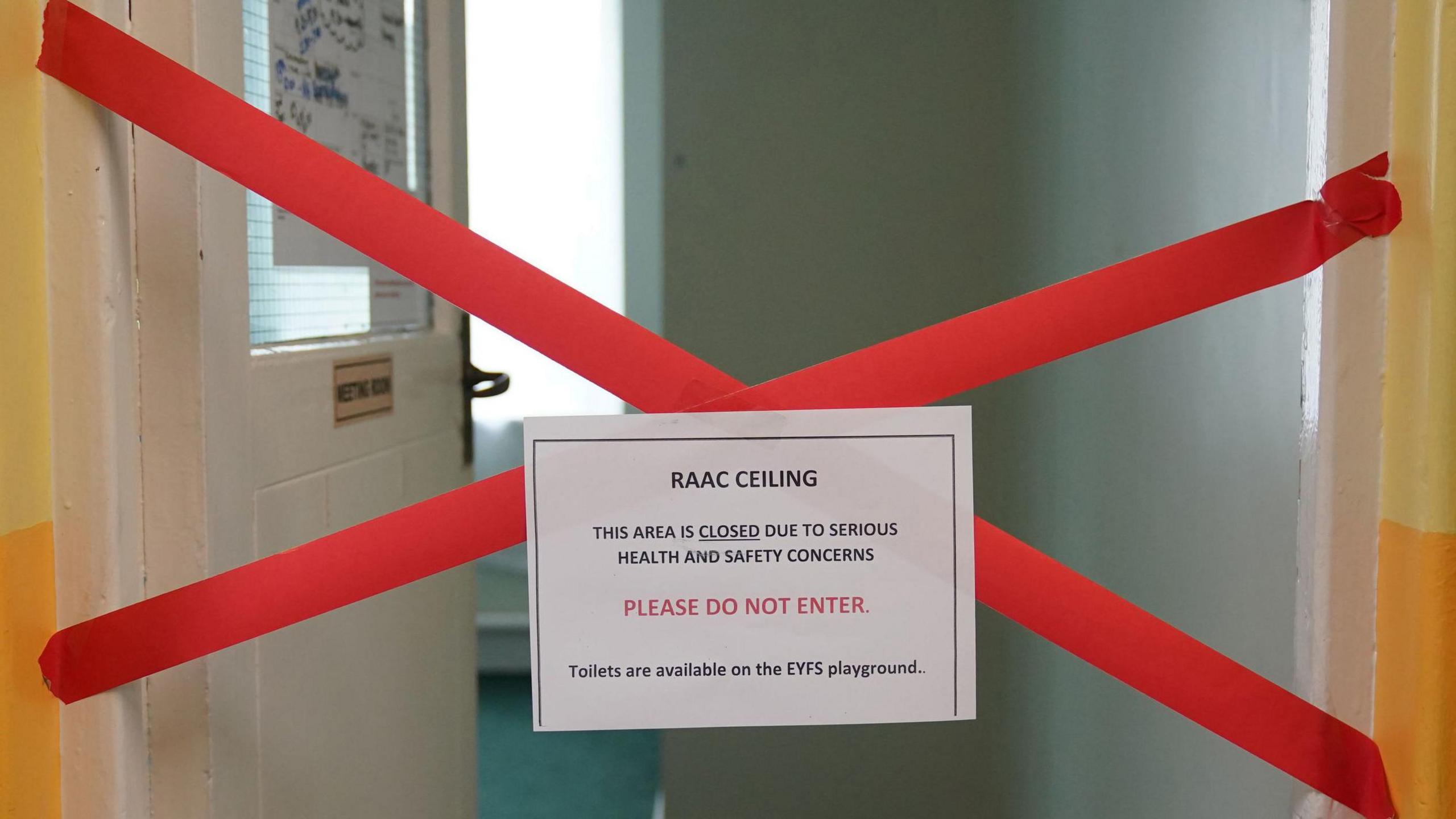 A school toilet is closed to pupils - there is red tape across the door and a sign that says "this area is closed due to serious health and safety concerns. Please do not enter". 