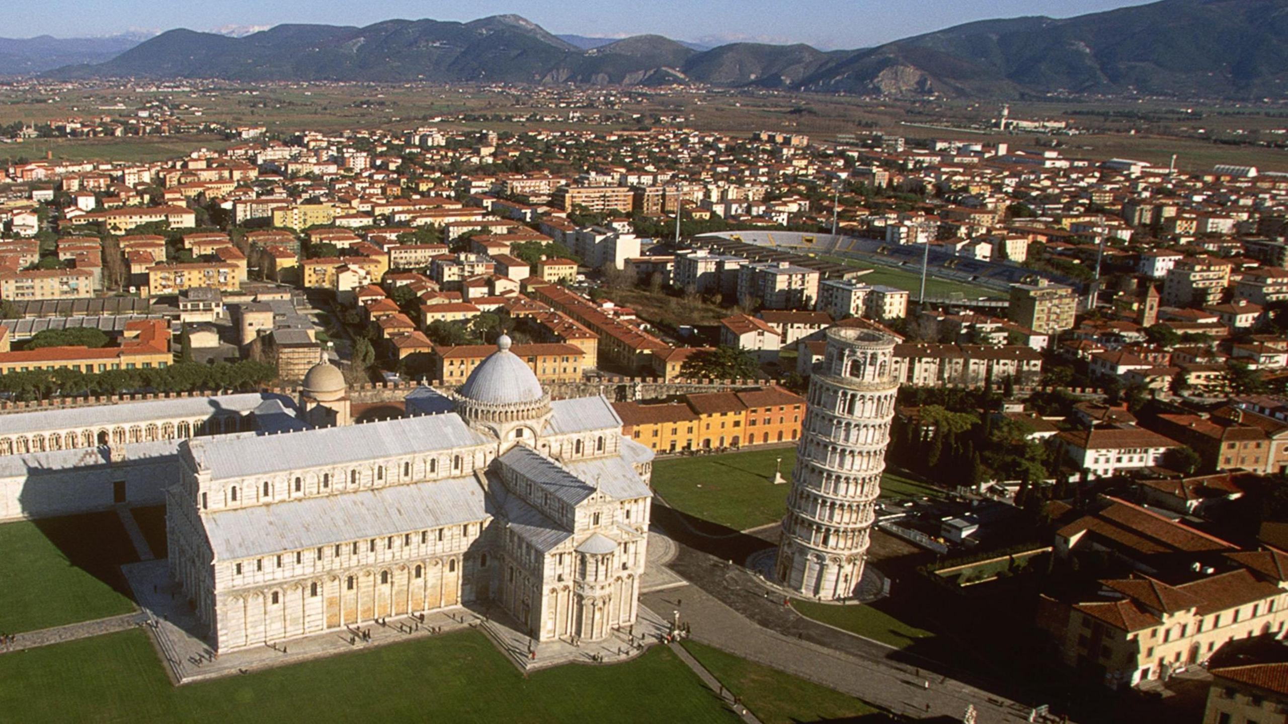 Leaning tower of Pisa with the city's football stadium in the background