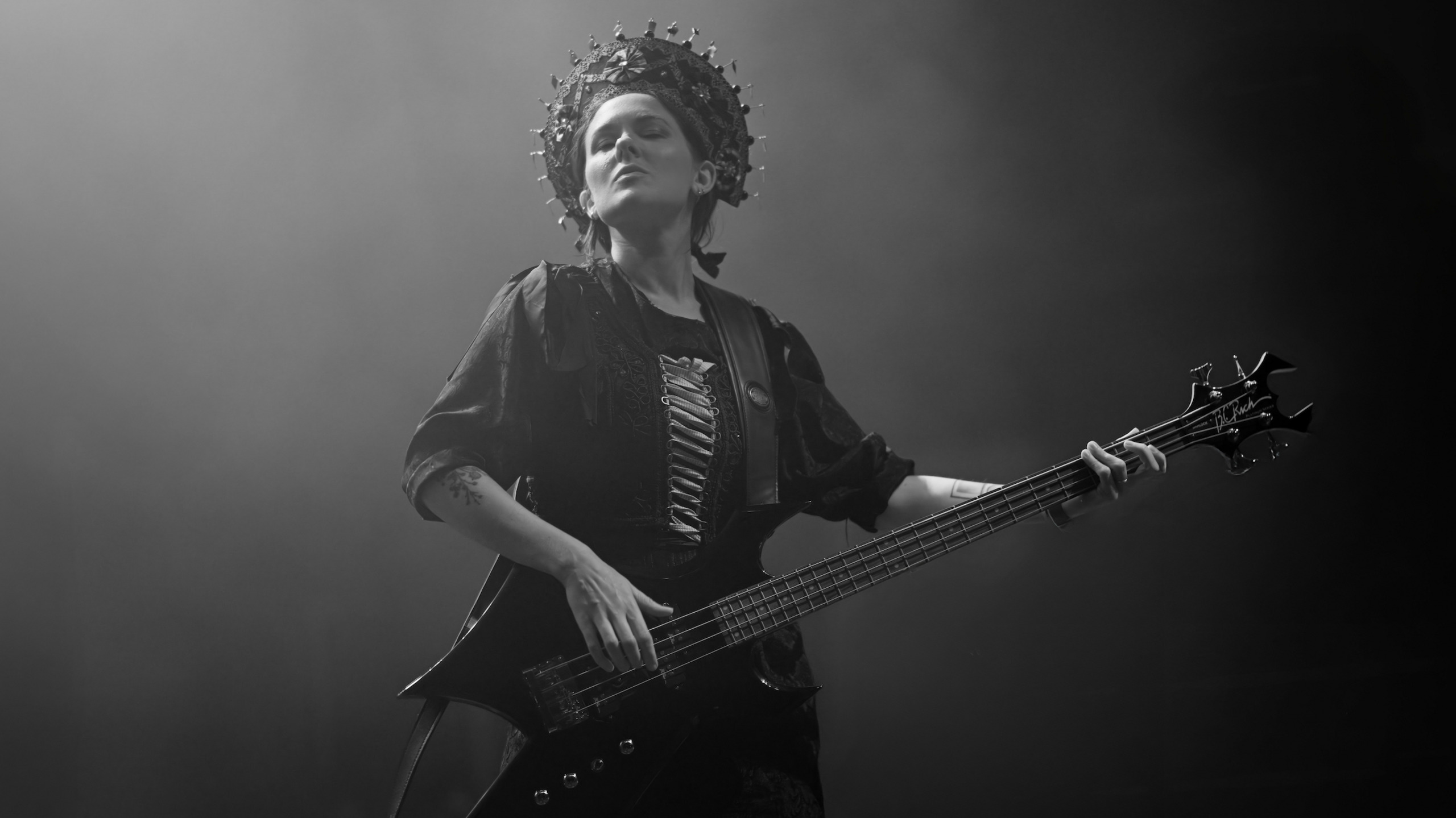 Funeral Folk guitarist wears dark clothes and a large headdress. 
