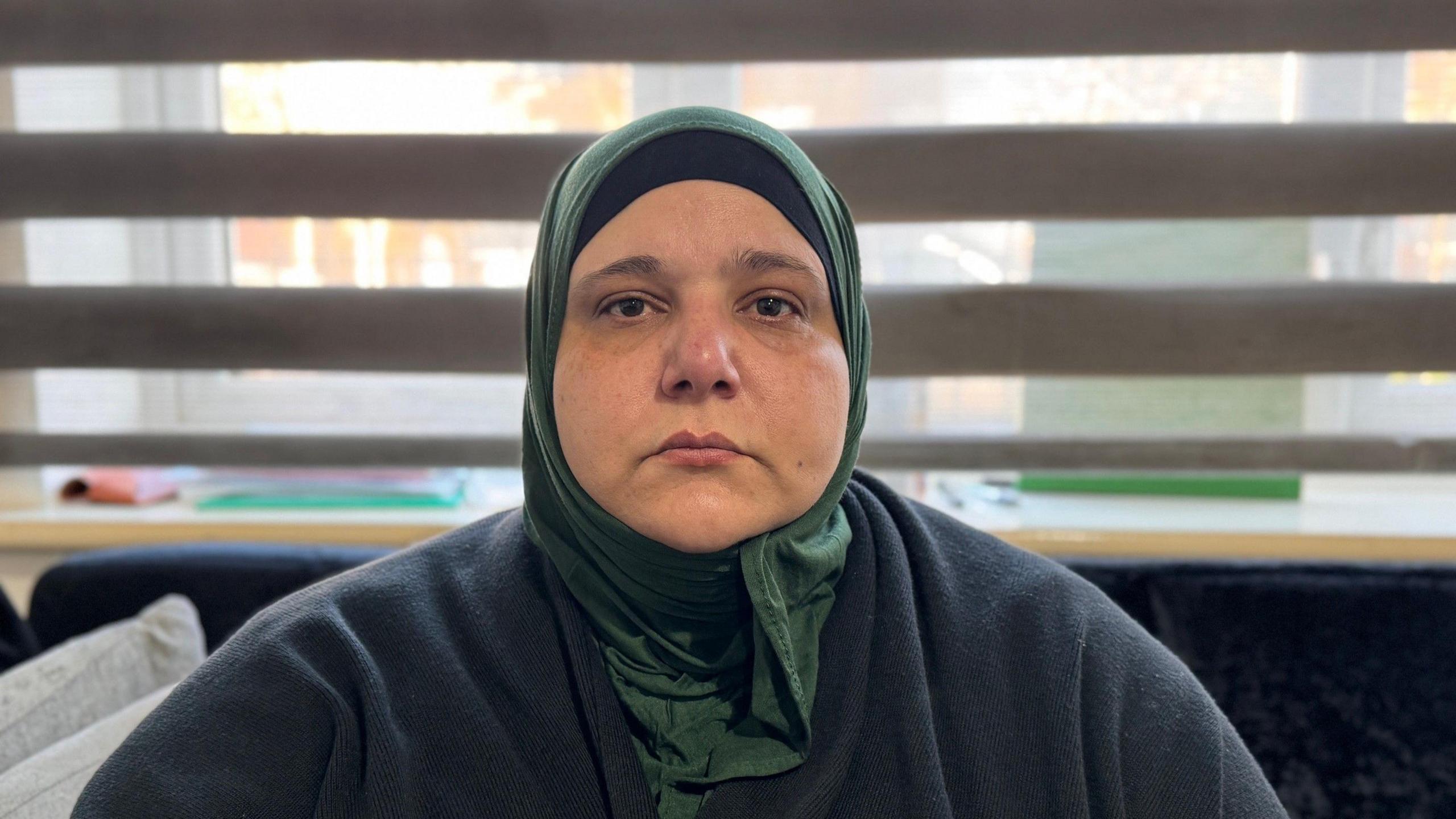 A photo of Arwaassi Asmael looking upset, wearing a headscarf
