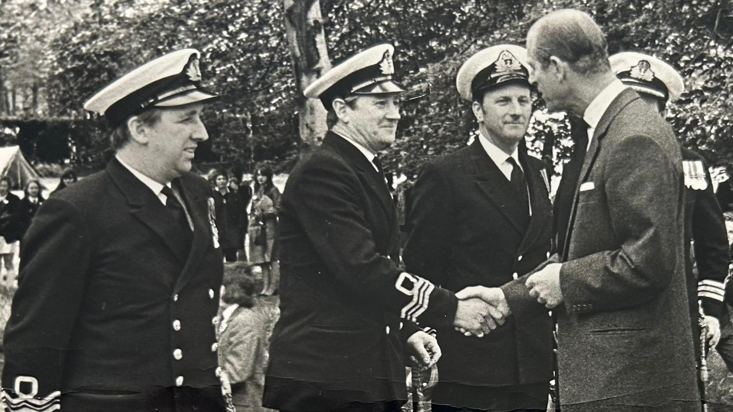 Mr Draper pictured in 1972 with Prince Philip, wearing a military uniform and shaking his hand 
