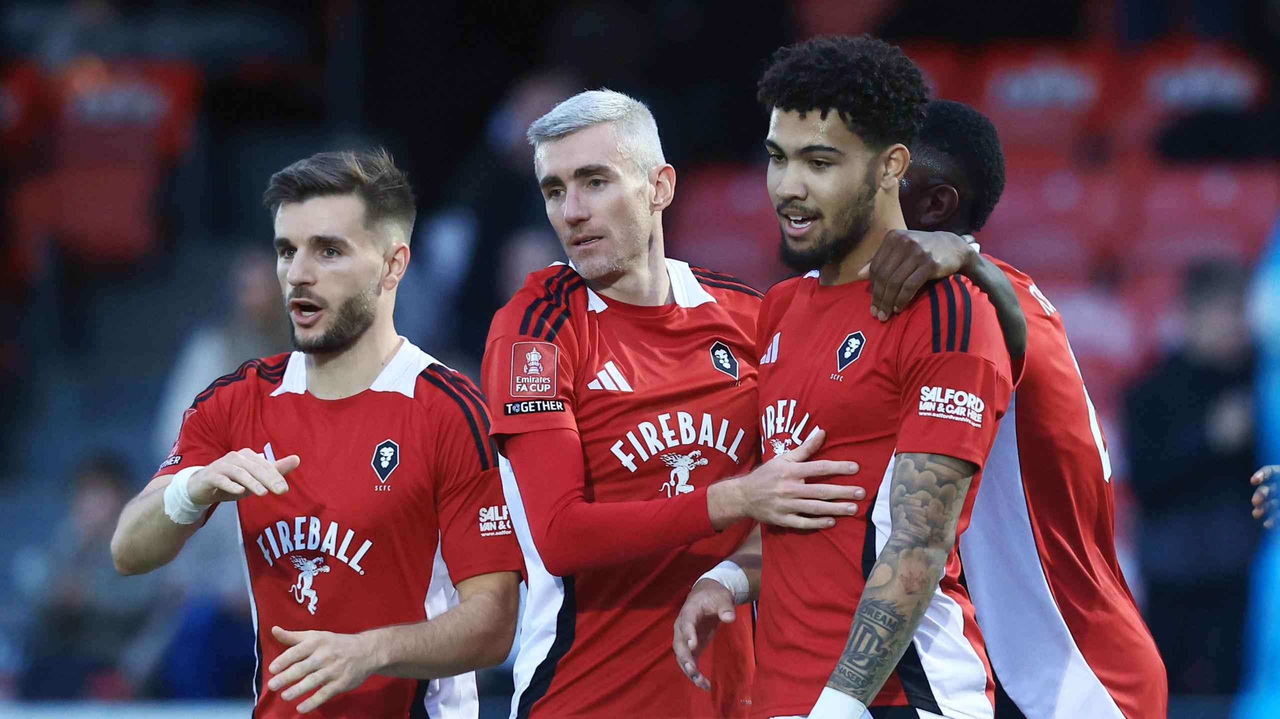 Francis Okoronkwo of Salford City celebrates scoring the opening goal with team-mates