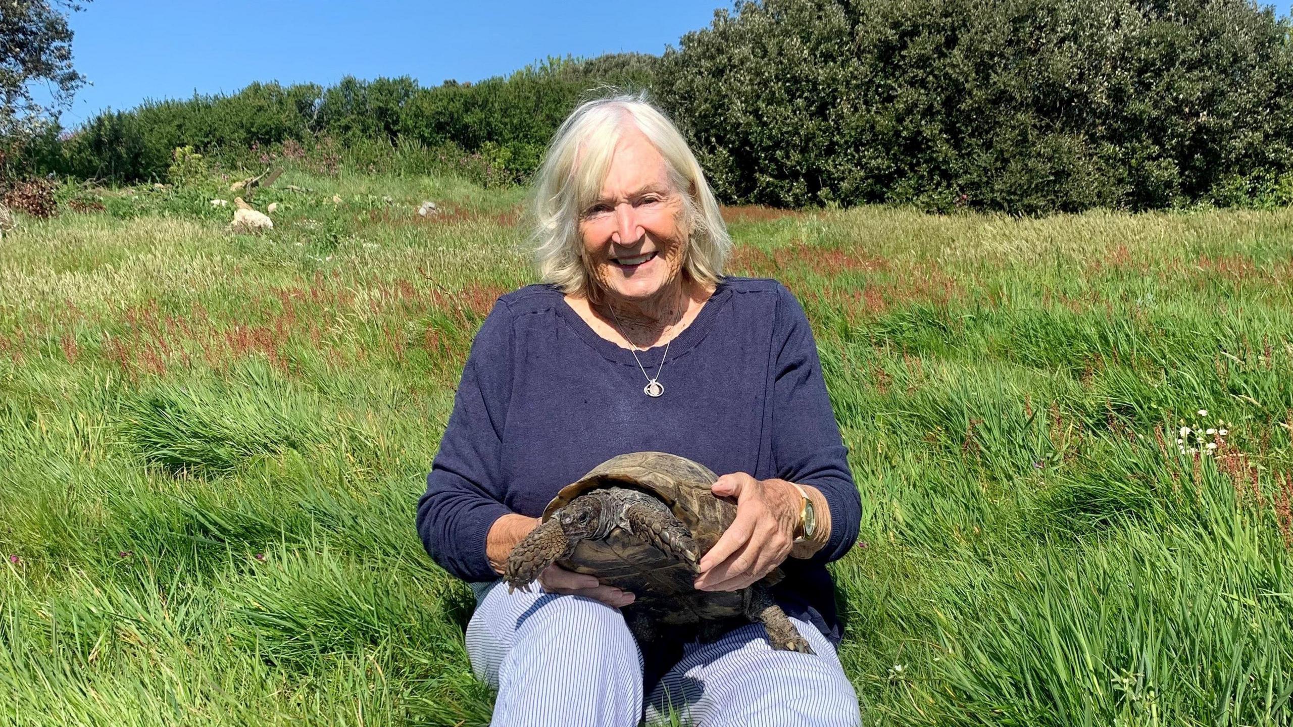 Timothy and Mrs Cull sat on some grass.