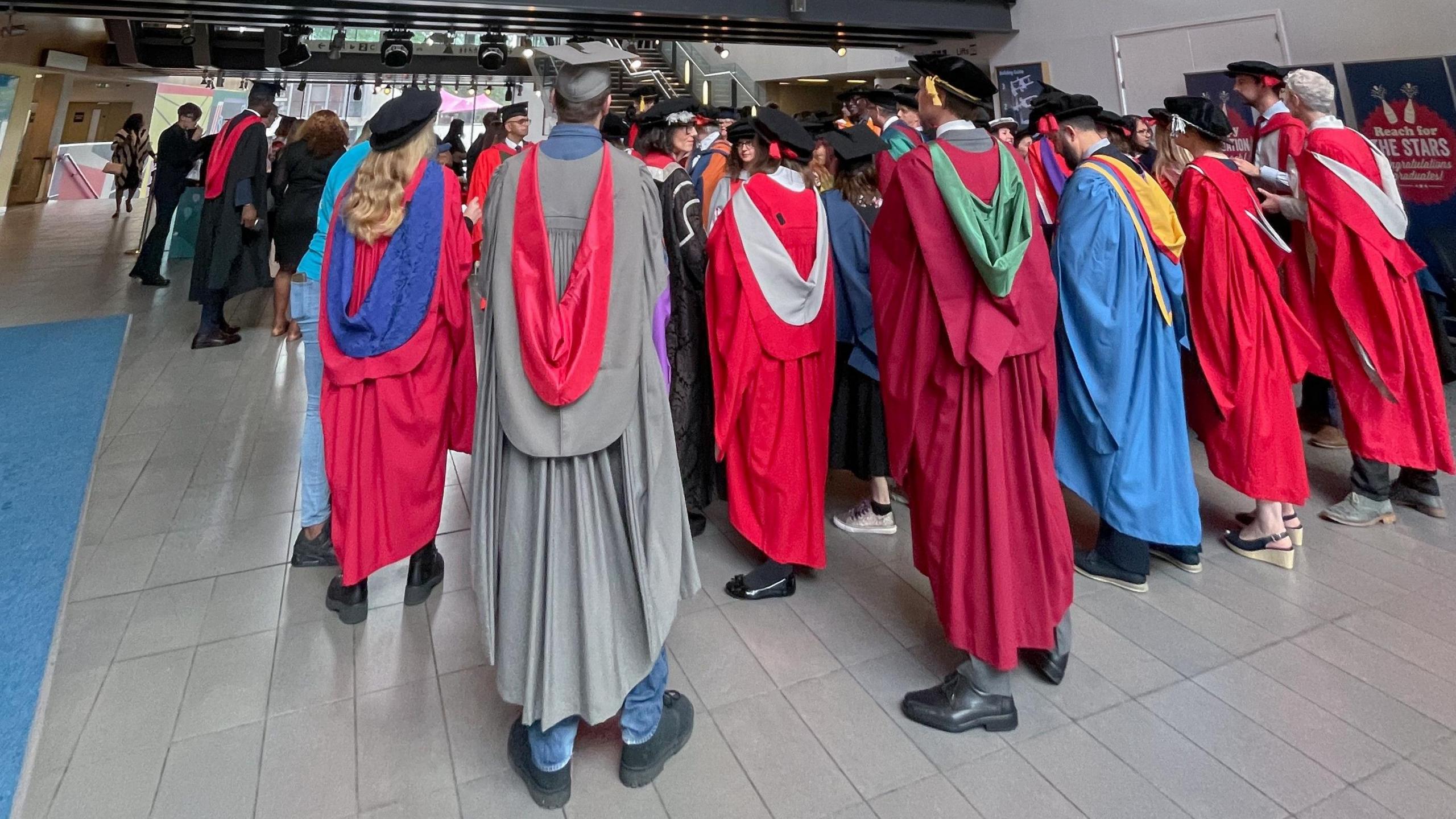 UWE students in their graduation robes and hats in the foyer at the Bristol Beacon