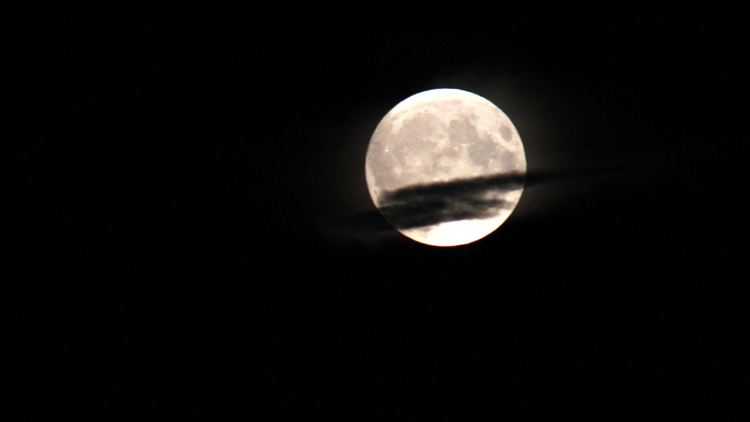 The supermoon, partially obscured by cloud