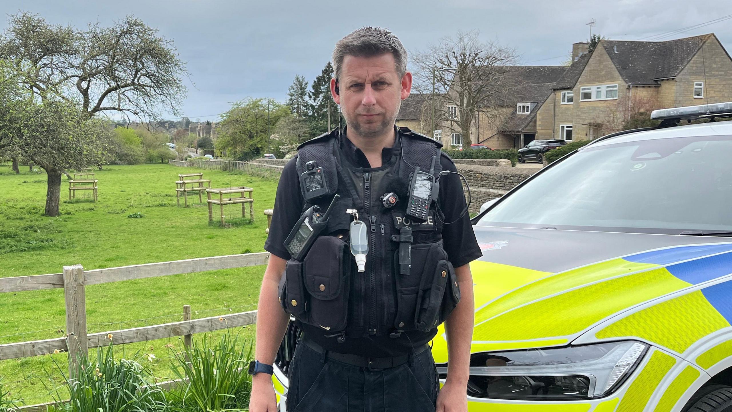 Acting Insp Gareth Gladwin stood next to a police car