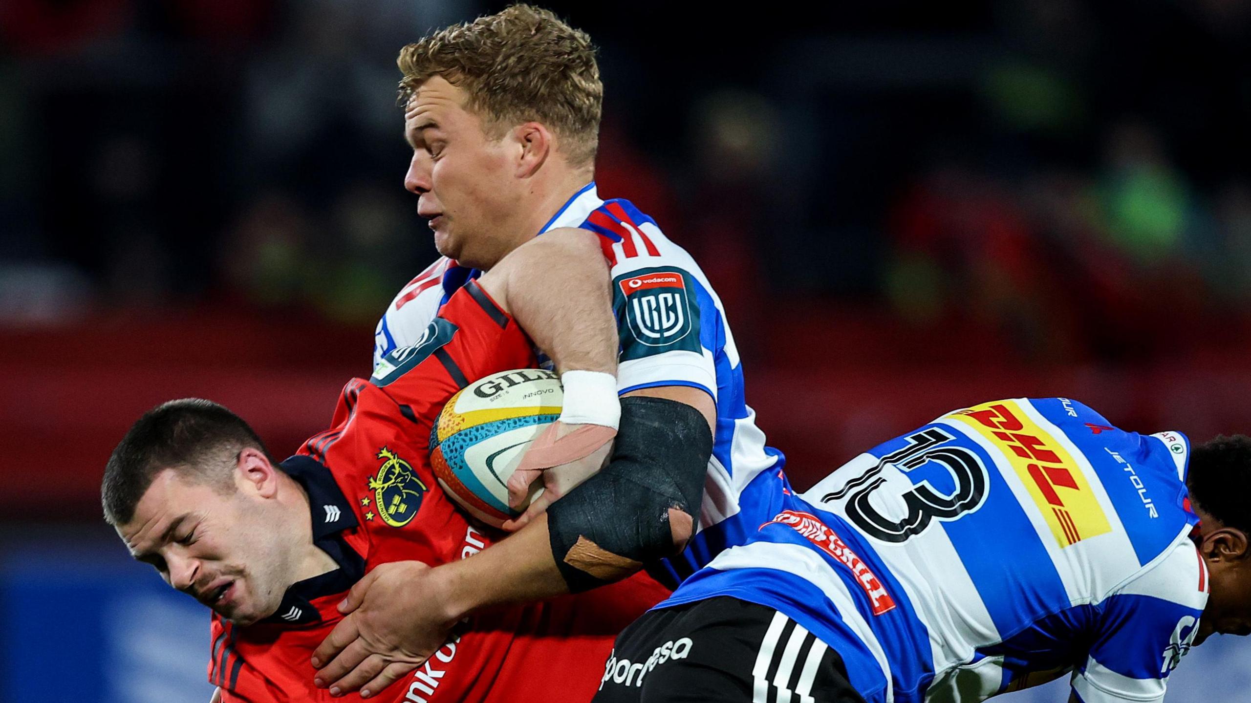 Munster's Diarmuid Kilgallen is tackled by Connor Evans and Wandile Simelane