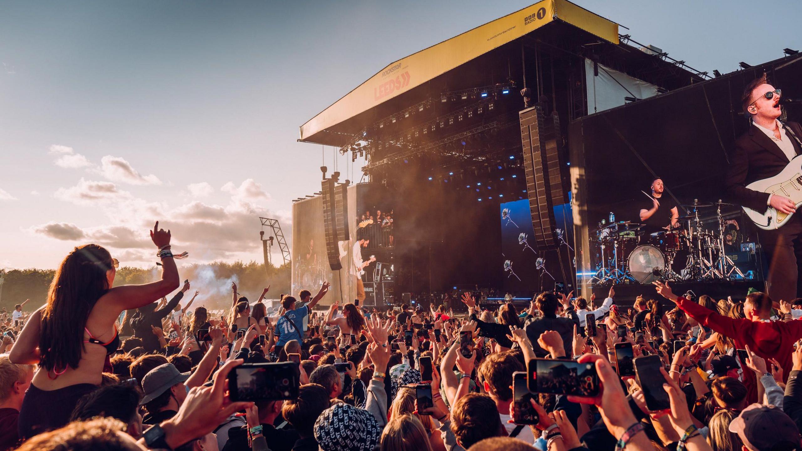 Leeds festival 2024. Crowds gather in front of the main stage on a summer's evening. 