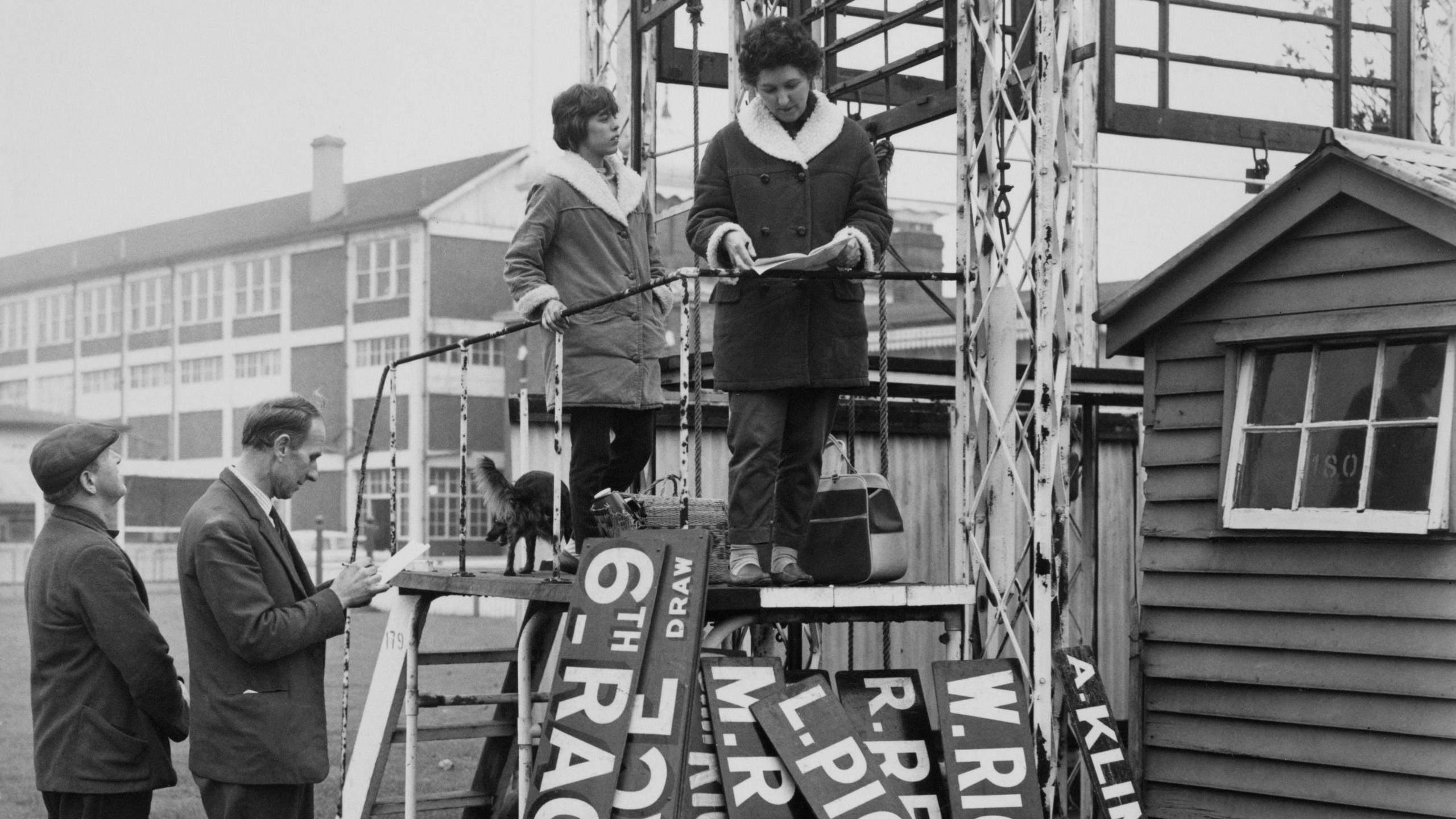 Race number and jockey name signage boards including that of Lester Piggott are examined by potential buyers at auction as the Hurst Park racecourse is closed down on 5th November 1962 at the Hurst Park racecourse at Moulsey Hurst, West Molesey, Surrey, England.