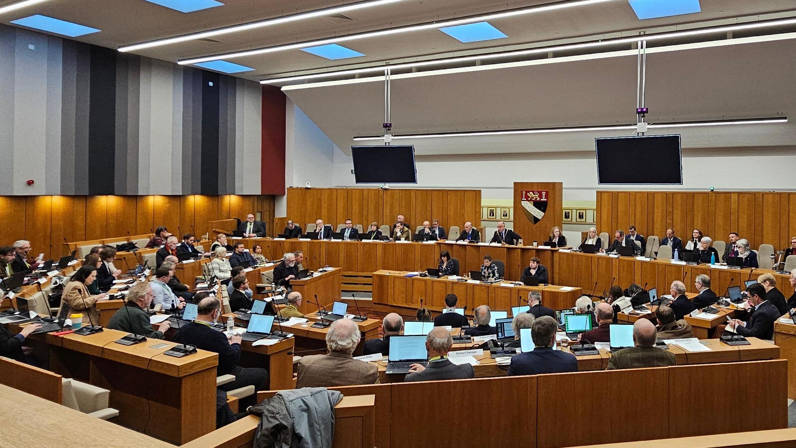 This is Norfolk County Council's main chamber. It's wood-panelled with most seats taken, and around 60 councillors in attendance.