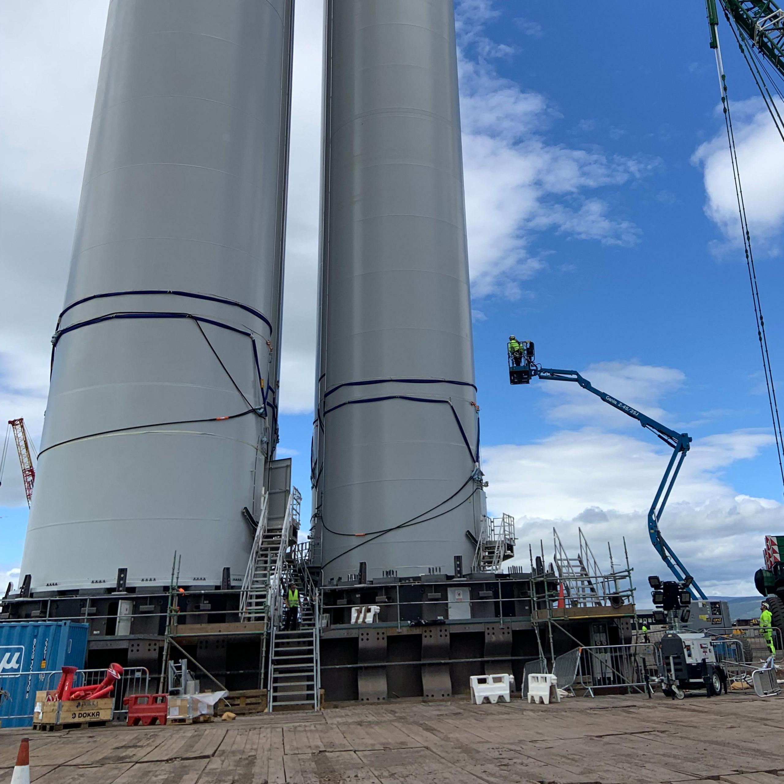 View from the ground of two wind turbine towers