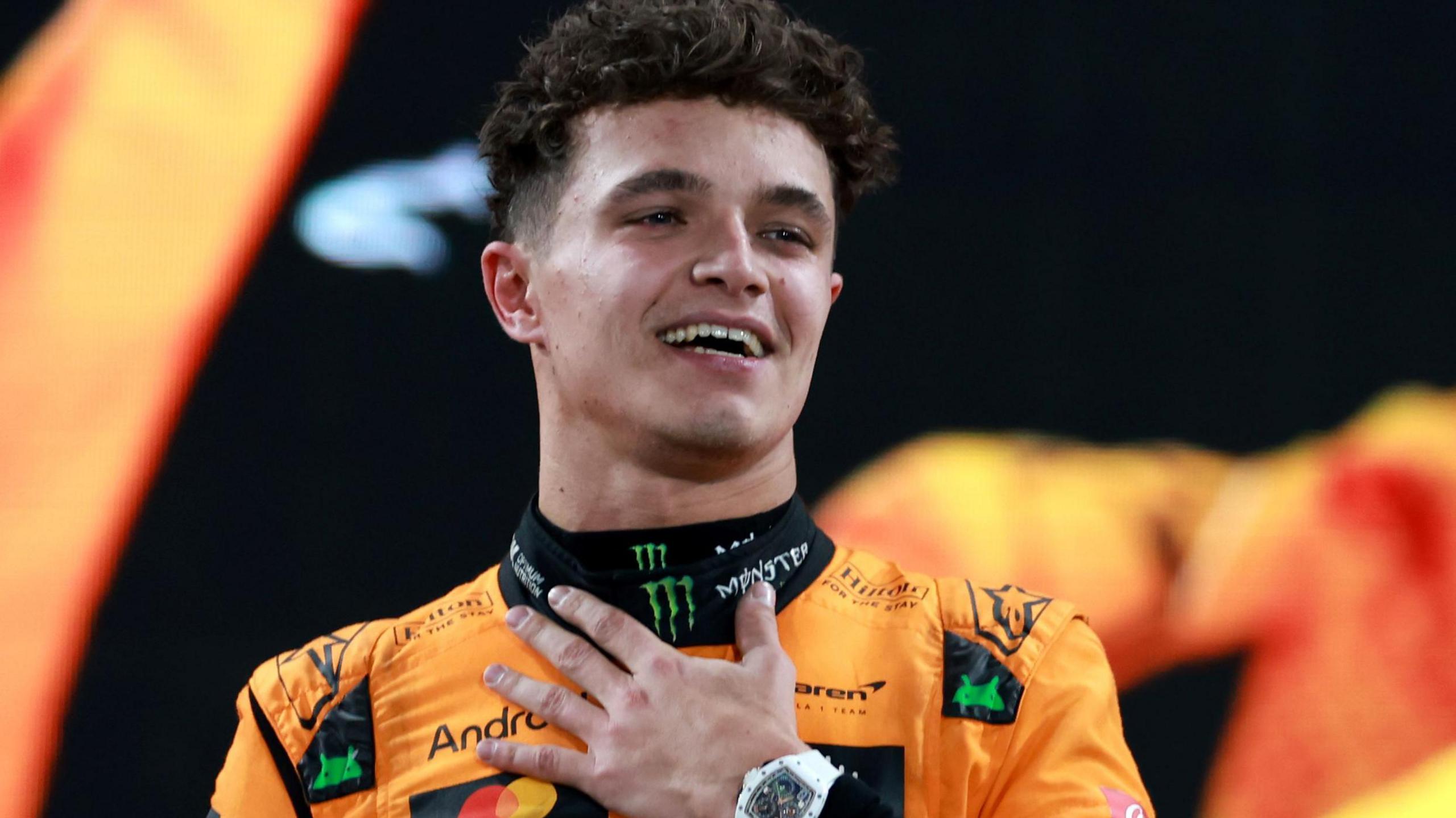 Lando Norris holds his left hand to his chest while celebrating victory in the 2024 Abu Dhabi Grand Prix