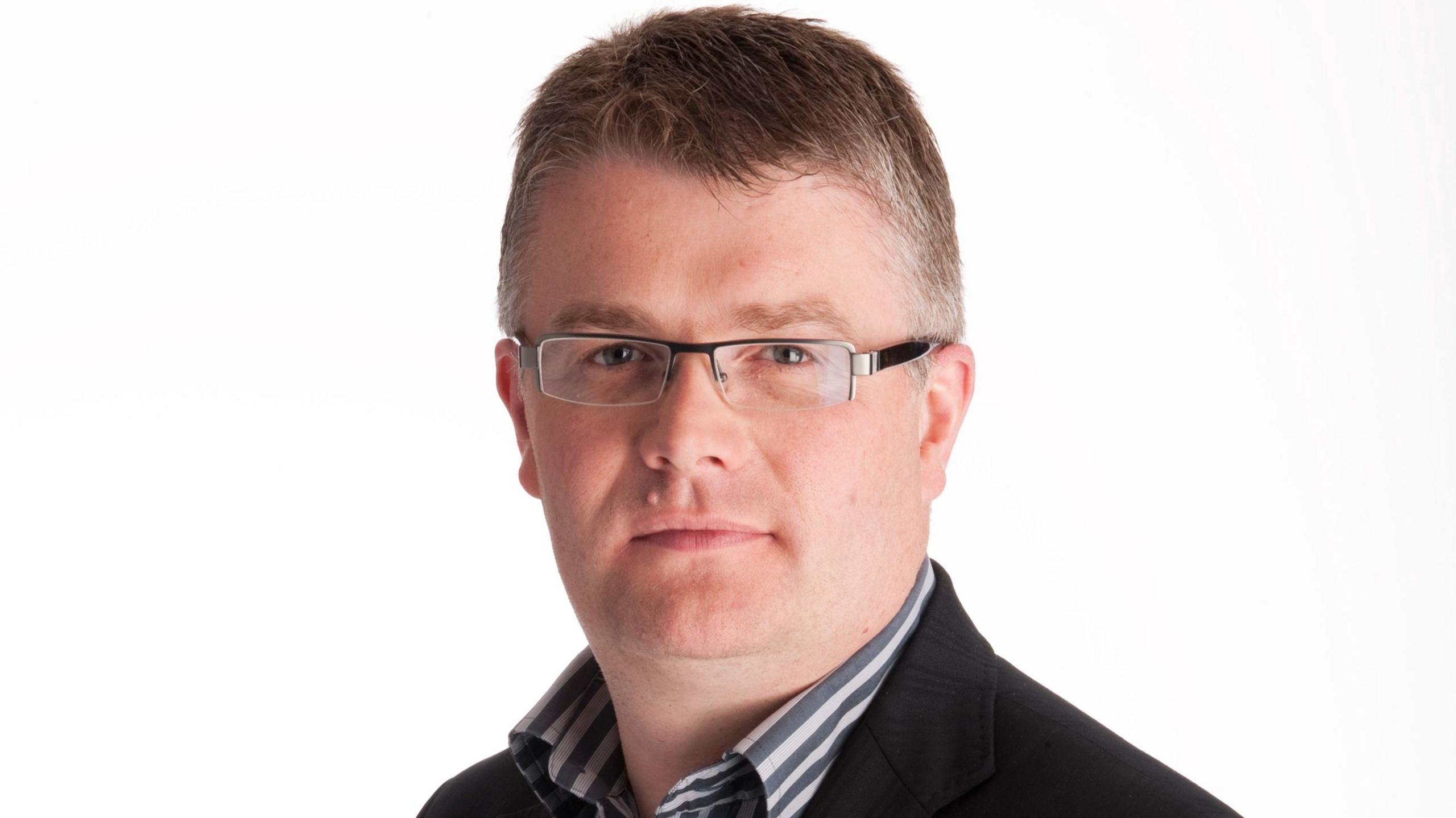 man with brown hair and glasses