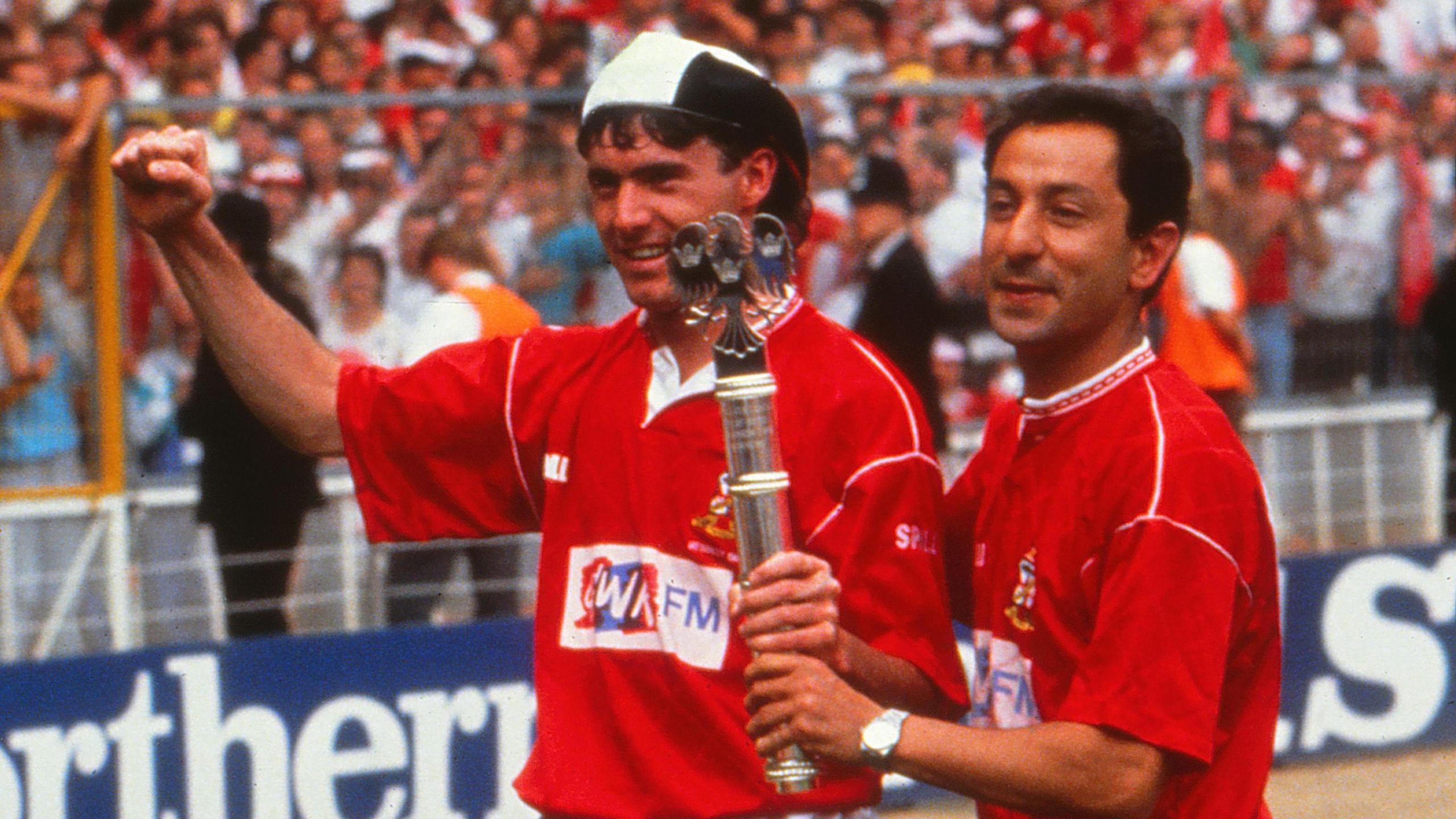 Swindon goalscorer Alan McLoughlin and player/manager Ossie Ardiles in red Swindon kits hold the play-off trophy